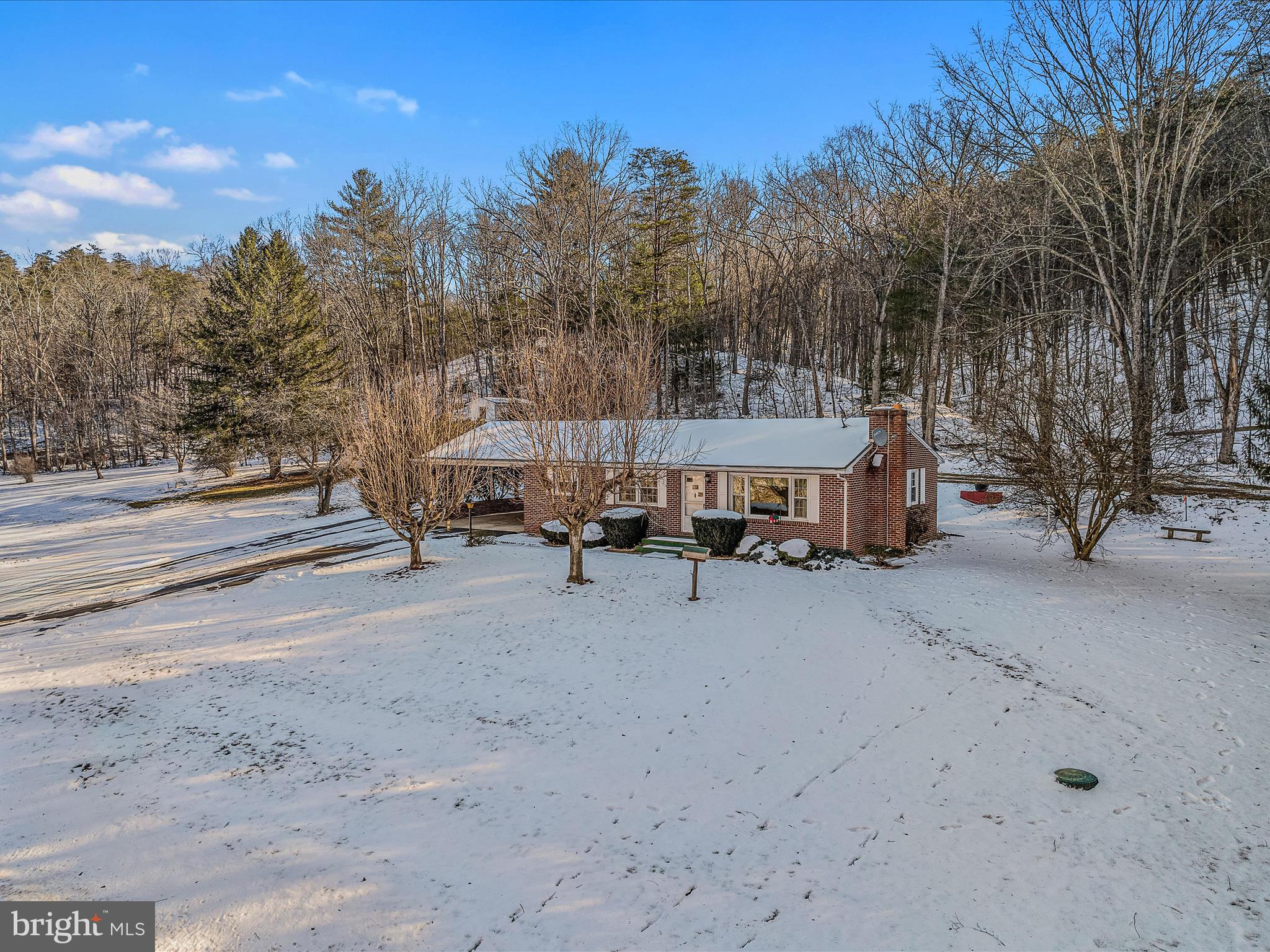 Very well maintained all- brick ranch home sits on .57 ac with additional 1.49 ac that conveys w/ sale.  Nice outdoor space /setting for all those reunions and gatherings. Main level features 3 bed and bath, beautiful hardwood throughout, newer windows, retro style kitchen and a relaxing brick fireplace in the living room for the chilly nights. Lower level  expands your living space featuring separate finished rec room with woodstove and built-ins, laundry area, 2nd bath w/ shower stall, canning style kitchen w/vintage stove. Upgraded electrical system, new HWH, new heat pump. Outside there is a storage building , separate root cellar and an upper room w/electric. Paved circular driveway on county maintained road and only about 15 minutes to downtown Berkeley Springs. Come see the many possibilities with this property