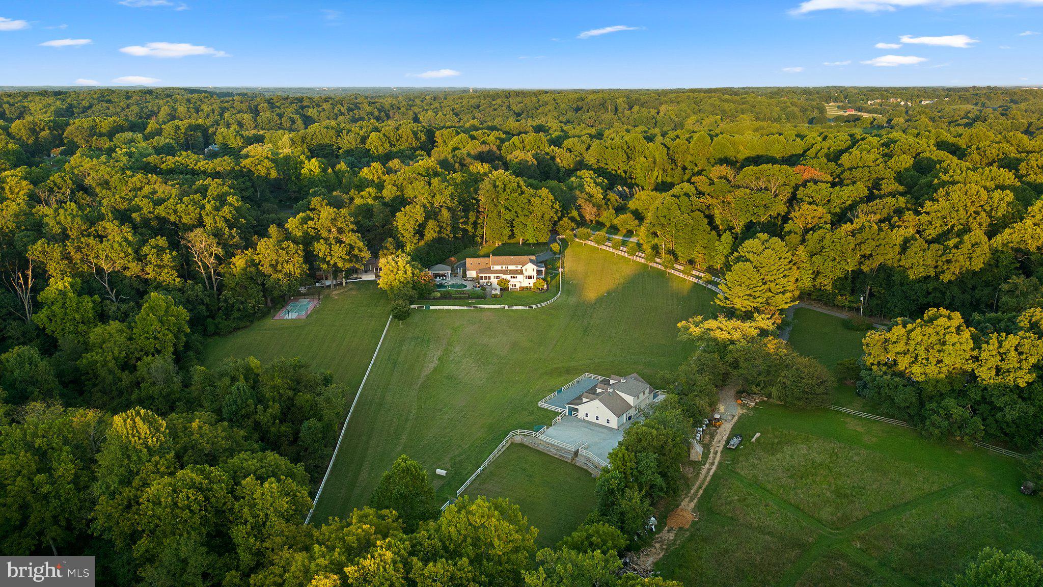 Proudly presenting one of the most exquisite farmettes ever constructed in Howard County; 7122 Deer Valley Road. A property of this caliber becomes available for sale once in a lifetime. Enter the realm of unparalleled luxury and sophistication, where equestrian dreams become reality. Fully reconstructed inside and out over the last several years, and sited in the River Hill High School district, this elite equine estate offers a sanctuary for both horse and rider. The property is a masterful blending of world class equine facilities with one of the finest homes ever constructed in this region. Spread across 5.38 acres of fully-fenced, private grounds, this property harmoniously blends natural beauty with refined living. The panoramic views of rolling pastures and lush woodlands provide a picturesque backdrop, creating an idyllic setting for both relaxation and recreation. With over 5,700 total square feet of high-end finishes and high-demand features, the main home provides you with ample space, exquisite detail, and the modern functionality you expect from a luxury home, while at the same time honoring the rich equine heritage of Highland with the farmhouse character and design. From the automatic front gate, to the massive parking area, the covered front porch, stone exterior, and expansive, professionally landscaped beds, to the world class fitness center and outdoor entertainment area complete with the fire pit, full outdoor kitchen, and massive salt water pool overlooking the pasture, this property stands out as a premium offering in every way. The high-end kitchen is a masterpiece, featuring the finest in luxury appliances and bespoke craftsmanship. A Sub-Zero refrigerator and wine cooler, symbols of unparalleled freshness and precision, paired with top-of-the-line Wolf appliances, including a state-of-the-art gas range, built-in wall ovens, sleek microwave, warming drawer, and ice maker, this kitchen is designed for both the gourmet chef and the casual cook. The kitchen's crowning glory is its custom cabinetry, crafted with outstanding attention to detail. The spacious, beautifully designed layout includes an expansive island with a polished granite countertop, perfect for both everyday meals and grand gatherings. The kitchen is bathed in natural light, offers a breathtaking view of the pasture, highlights rich textures and finishes, and creates a warm, inviting atmosphere. Embrace the art of cooking in a space that combines luxury, style, and function to create the ultimate kitchen experience. The centerpiece of the property is the state-of-the-art equestrian complex. The main barn features three spacious, climate-controlled stalls, each equipped with premium rubber flooring, fly control system, and automatic waterers. Adjacent is a sophisticated tack room, feed room, a grooming area, and a wash stall with hot and cold water. A separate riding ring equipped with LED lighting allows you to ride into the night and provides multiple locations on the property to practice. This resort-style home will become your friends and family’s favorite place to visit. The barn conveniently offers a two level apartment complete with a full kitchen, bathroom, bedroom, and sizable living space. The barn also offers the perfect space for automotive collectors, artists/musicians, or your home business - ask for additional detail on the variety of possibilities for this space. The home, barn, and all equipment are in pristine condition and have been updated according to the luxury home standards of today. For a full list of features, finishes, ages, and improvements please reach out directly. This home will be expertly transferred to the new owner through a warm handoff and thorough orientation of all systems and operations.