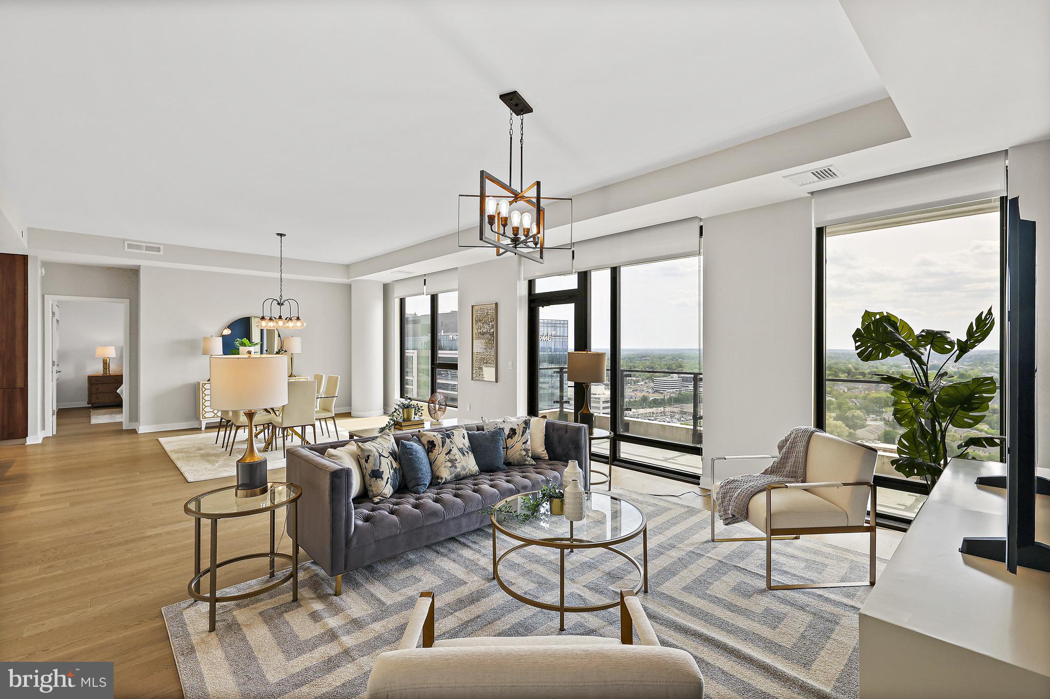 Located in the Verse at the Boro, Tysons’ most sought after full service residential building, this stunning 22nd Penthouse floor level residence with soaring ceilings exudes sophistication, ease, and delight throughout every space.   With 2 Bedrooms, 2 Full Bathrooms, one Half Bathroom, and a Den with a door and windows, 2206 is one of three residences in the building featuring this exceptional floorplan.  Stunning western sunset views illuminate the open main living area through floor-to-ceiling windows while the expansive wrap around balcony extends living space to the outdoors.  Gorgeous wide plank wood floors flow seamlessly throughout the spaces.  The modern and sleek Kitchen by Cecconi Simone features Italian cabinetry, quartz countertops and full height backsplash, oversized island with waterfall counter and seating for 4, Bosche appliances, and custom-built pantry closet and is open to the Dining and Family Rooms. The large and serene Primary Bedroom Suite has a dream walk-in closet with high-end custom-built cabinetry and multiple wardrobe mirrors, 2 additional walk-up closets, and a luxurious Bathroom with dual sink custom Italian vanities, porcelain tile, frameless glass shower with bench and niche, and separate water closet.  Bedroom 2 has an equally impressive closet with custom built-ins and an en suite Bathroom with tub.  A full size Laundry Room and Powder Room complete the main residence.  The property includes 2 parking spots in the secure garage and a separate storage unit.  The Verse offers 24 hour concierge, automated package retrieval, pet spa, state-of-the-art fitness studio, yoga room, guest suite, and massive sky park for entertaining, relaxing, or grilling out!   Modern restaurants, unique shops, the Icon Movie Theater, and the best Whole Foods on the east coast are right at your fingertips.  Close to the Greensboro Metro Stop.  The best that Tysons has to offer!