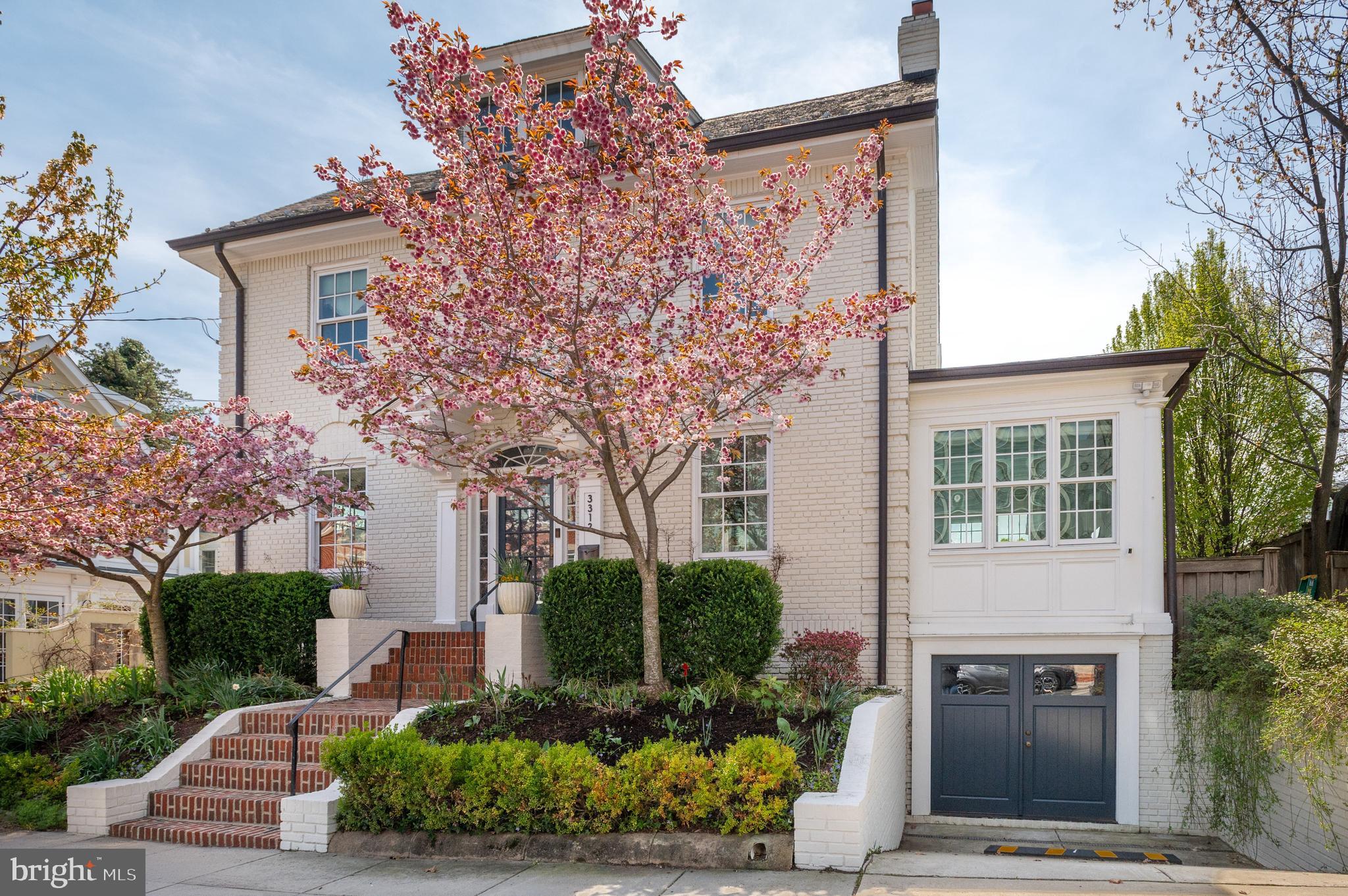 Nestled in the heart of Cleveland Park, 3312 Lowell St NW is a storybook Colonial reimagined with a designer’s eye and a reverence for timeless architecture. Wrapped in classic white brick and framed by mature trees and curated landscaping, the home feels both iconic and quietly set apart.

Originally renovated top-to-bottom in 2014, this 5-bedroom, 4.5-bath residence spans approximately 4,200 square feet across four beautifully finished levels—each space thoughtfully restored and elevated with high-end, design-forward finishes.

Inside, a gracious foyer sets the tone, flanked by a warm, inviting family room lined with custom built-ins and a formal living room anchored by a fireplace. The living spaces unfold effortlessly into a refined dining room, creating a natural flow for both everyday living and entertaining. Beyond, the gourmet eat-in kitchen is a true centerpiece, featuring marble countertops, bespoke cabinetry, and top-tier stainless steel appliances, with seamless access to the expansive deck and private rear yard.

A light-filled four-season sunroom offers the flexibility of a playroom, studio, or home office, while a butler’s pantry and powder room complete the main level with ease and elegance.

Upstairs, the second level hosts three well-appointed bedrooms and two baths, including a serene primary suite with dual custom walk-in closets and a spa-inspired ensuite bath with dual vanities and a walk-in shower. Two additional bedrooms share a thoughtfully designed Jack-and-Jill bath.

The top level offers a rare vantage point, with a charming balcony framing views of the Washington National Cathedral. Two additional bedrooms, a hall bath, and a versatile bonus room—ideal for a home office, gym, or creative space—complete this level.

The lower level is equally considered, featuring a spacious recreation room, an additional bedroom and full bath, laundry, storage, and a mudroom. With its private entrance, this level easily functions as an in-law or au pair suite.

Outdoors, the fenced backyard is both private and inviting, with a flat lawn, expansive deck, and lush professional landscaping—an ideal setting for quiet mornings or lively gatherings.

Perfectly positioned in the heart of Cleveland Park, this home offers effortless access to neighborhood favorites along Connecticut Avenue NW, nearby parks and trails, and the Metro, blending tranquil residential living with the best of city convenience.
