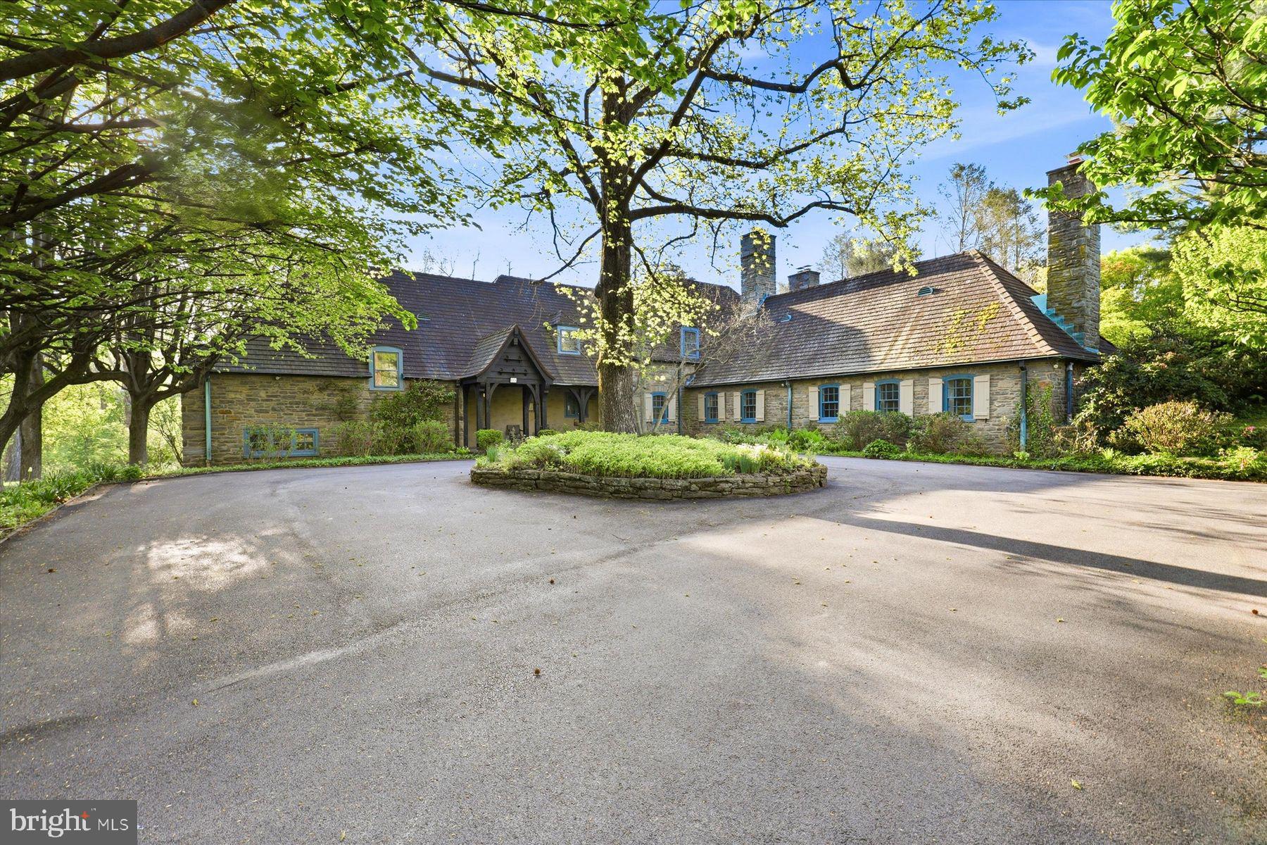 Welcome to 500 Telner Street, one of the finest Woodward houses in Chestnut Hill. Built in 1957, but resembling a 1925 house typical of the aesthetics of Chestnut Hill, this lovely estate was custom built for George Woodward, Jr. and his wife Harriet for their personal home. The Woodward family is well-known for building Chestnut Hill’s most charming estates. Its park-like setting and charming dovecote gracing the front entrance, surrounded by pink azaleas in Spring, make this fairy tale “cottage” come to life. This is one of the rare homes directly on Wissahickon Valley Park. Timeless charm, so typical in Woodward architecture, is brought to its zenith in this stone home, custom built to plans now archived at the Chestnut Hill Conservancy, with seemingly no expense spared. All the modern amenities you love, such as central air, a full 2 car garage, an attached separate apartment with its own private entrance, 5 full and 3 half baths (each bedroom and apartment with their own full bath), and enormous closets and attic space, offer comfort and convenience. With 8 inch deep granite window sills due to the thick walls, the house is exceptionally quiet due to the insulation, solid doors and stucco walls. Uniquely, the primary bedroom suite occupies an entire wing on the ground floor and features a spacious bath with dual bathrooms, each with its own shower or tub. The generous bedroom includes French doors opening to a private patio, a marble fireplace, built-in dresser, and separate closets, along with an adjoining sitting room with an additional marble fireplace. This wing creates total privacy from the other living spaces in the house. The grand living room, with an open floor plan connecting to the dining room, boasts 5 sets of French doors that are lit with morning sun, with an unobscured view filled with trees as it overlooks Cresheim Valley. Since 2013, multiple improvements have been made, including a new main kitchen with radiant floor heating, a Miele dish washer, Viking stove, convection oven, and a generous pantry complete with a cozy, sunny home office. The kitchen in the apartment is also new, with granite countertops, gas range and dishwasher, and added in 2020, a spacious southern exposure insulated glass addition opens out from the living room for your hot tub, 4 season relaxation and plant cultivation or display. A kitchenette is also located here. The circular and garage access driveways were repaved in 2023. The generous studio apartment has a separate entrance and contains multiple windows, a full bath and ample closets. The second floor contains 3 bedrooms and luxuriously, one full bath for each bedroom. Adding to the home's flexible layout is the possibility of complete separation of upstairs and downstairs due to the private entrance access to both the upstairs and the apartment. A large slate floor foyer at the front door absorbs all the comings and goings and stands the test of time. Located over the furnace room, the slate remains warm all winter long. A massive “playroom” in the finished basement, complete with fireplace, could be an exercise space, a guest bedroom (it has a large window), office, child or party space. While laundry is conveniently located on the ground floor, there is plumbing here in a large closet for another laundry facility. There is also a half bath in the basement and a very generous workshop space as well. An additional finished room which, at the owner’s option, could be reserved for the resident of the apartment to enlarge its capacity, or kept as part of the main residence.