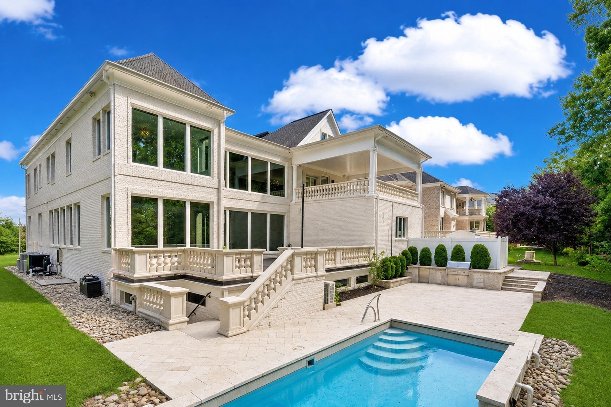 A glass-and-light modern masterpiece, this custom residence by Potomac Custom Homes spans nearly 10,000 finished square feet on a quiet cul-de-sac in The Reserves at Pinecrest, privately backing to protected Fairfax County parkland. Expansive walls of glass and dramatic vertical spaces set an unforgettable tone, anchored by soaring 20-ft ceilings in the main living area and the primary sitting room, with 10-ft ceilings throughout the rest of the home. A custom floating staircase wrapped in fully enclosed glass railings rises through every level, while large-format Roberto Cavalli porcelain flooring and radiant heat bring warmth and cohesion to the main living spaces.

At the heart of the home, a chef's kitchen is designed to impress: custom Italian UNICA cabinetry, 3-inch DEKTON Aura waterfall countertops, a professional GE Monogram appliance suite with induction range, and an expansive island built for gathering. GROHE designer fixtures and copper supply lines reflect a commitment to quality throughout.

Designed for entertaining and everyday escape, the finished lower level delivers a dedicated home theater, a golf simulator room with an $80K build-out, and a private gym, with theater seating, projector and screen, and gym equipment all conveying.

Outdoor living rivals a private resort. A saltwater fiberglass pool with Pentair heating, LED lighting, a decorative waterfall, and an automatic cover is surrounded by an expansive patio with a built-in Weber gas grill, outdoor refrigerator, and integrated storage. Upstairs, the primary suite opens to a private balcony retreat with a hot tub overlooking the trees.

Smart and built to last, the home features Control4 whole-home automation, a hardwired security system, a full-house Generac backup generator, three-zone Carrier HVAC, and app-controlled Rachio smart irrigation. A spacious 4-car garage with 8-ft doors, epoxy floors, and custom storage, plus a mudroom with a built-in pet-washing station, complete the offering.

Minutes to I-495, I-395, Route 236, Route 7, and Braddock Road, with parks, golf courses, shopping, and dining close by, this is contemporary luxury with a true sense of retreat in the heart of Northern Virginia.