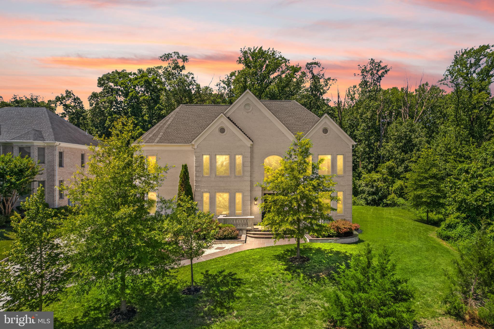 A glass-and-light modern masterpiece, this custom residence by Potomac Custom Homes spans nearly 10,000 finished square feet on a quiet cul-de-sac in The Reserves at Pinecrest, privately backing to protected Fairfax County parkland. Expansive walls of glass and dramatic vertical spaces set an unforgettable tone, anchored by soaring 20-ft ceilings in the main living area and the primary sitting room, with 10-ft ceilings throughout the rest of the home. A custom floating staircase wrapped in fully enclosed glass railings rises through every level, while large-format Roberto Cavalli porcelain flooring and radiant heat bring warmth and cohesion to the main living spaces.

At the heart of the home, a chef's kitchen is designed to impress: custom Italian UNICA cabinetry, 3-inch DEKTON Aura waterfall countertops, a professional GE Monogram appliance suite with induction range, and an expansive island built for gathering. GROHE designer fixtures and copper supply lines reflect a commitment to quality throughout.

Designed for entertaining and everyday escape, the finished lower level delivers a dedicated home theater, a golf simulator room with an $80K build-out, and a private gym, with theater seating, projector and screen, and gym equipment all conveying.

Outdoor living rivals a private resort. A saltwater fiberglass pool with Pentair heating, LED lighting, a decorative waterfall, and an automatic cover is surrounded by an expansive patio with a built-in Weber gas grill, outdoor refrigerator, and integrated storage. Upstairs, the primary suite opens to a private balcony retreat with a hot tub overlooking the trees.

Smart and built to last, the home features Control4 whole-home automation, a hardwired security system, a full-house Generac backup generator, three-zone Carrier HVAC, and app-controlled Rachio smart irrigation. A spacious 4-car garage with 8-ft doors, epoxy floors, and custom storage, plus a mudroom with a built-in pet-washing station, complete the offering.

Minutes to I-495, I-395, Route 236, Route 7, and Braddock Road, with parks, golf courses, shopping, and dining close by, this is contemporary luxury with a true sense of retreat in the heart of Northern Virginia.