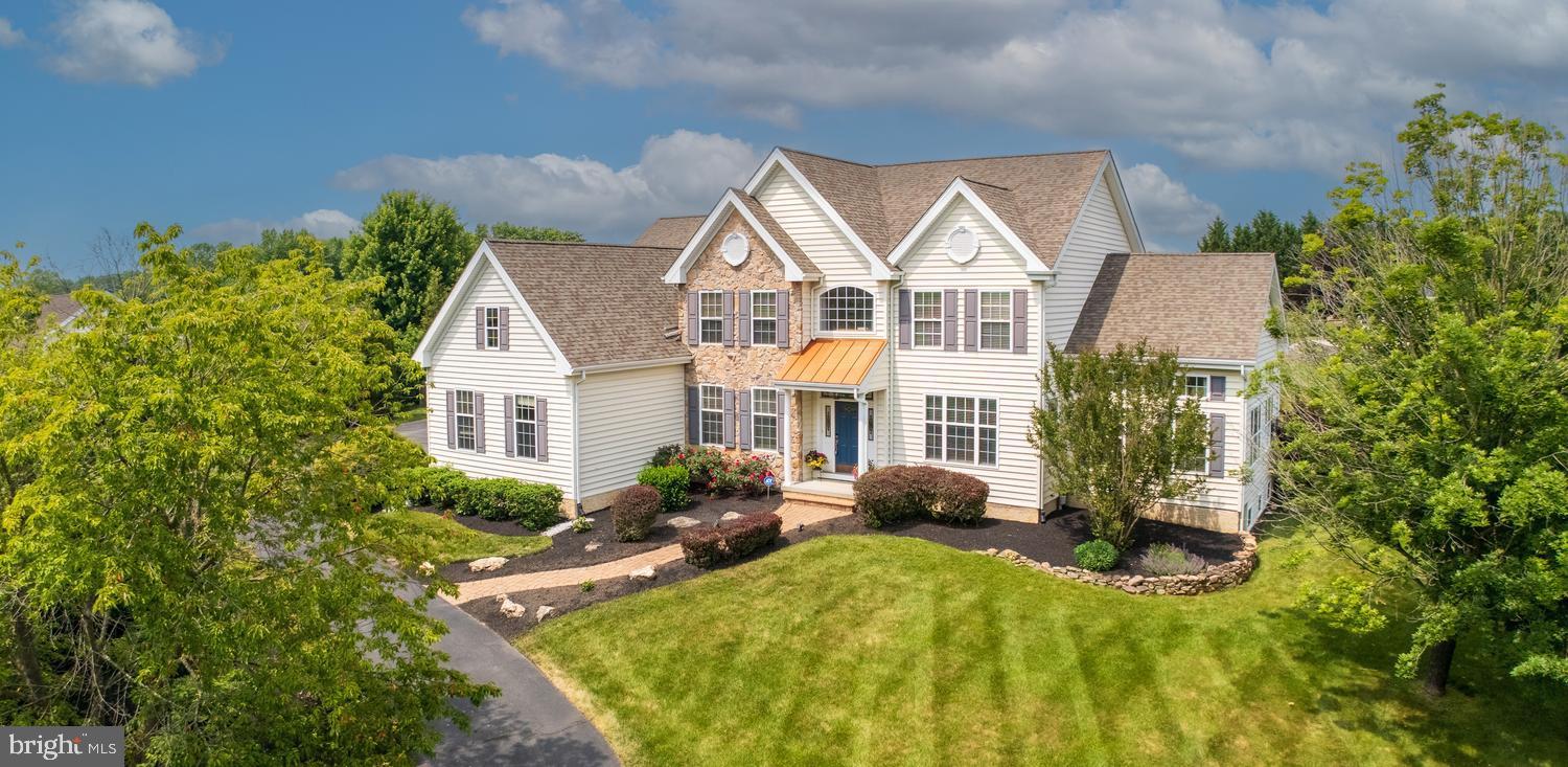 Gorgeous executive-style Wilkinson-built Ridgewood II model situated on a premium 1.06-acre homesite in the prestigious Elk Ridge Farms community. Offering approximately 4,000 square feet of elegant living space, this exceptional residence features 4 bedrooms, 2.5 baths, and an ideal layout for both everyday living and fun entertaining. A dramatic center hall entrance welcomes you into an open floor plan highlighted by formal living and dining rooms adorned with exquisite moldings and wide-plank Brazilian cherry hardwood floors that extend throughout most of the first level. Just beyond the impressive split staircase lies the heart of the home—a chef's dream kitchen featuring an oversized center island with seating, wine cooler, built-in microwave, bookshelves, granite countertops, and abundant workspace.
The kitchen is further enhanced by custom 42-inch upgraded wood cabinetry with soft-close drawers, stainless steel appliances, double ovens, a professional-grade Thermador gas cooktop, range hood system, dishwasher, walk-in pantry, stone backsplash, custom wall built-in and a spacious breakfast area.
Entertaining continues seamlessly into the inviting sitting room, showcasing a stunning see-through gas fireplace with custom molding and accent lighting. On the opposite side, the sun-filled conservatory features walls of oversized windows that frame picturesque views of the property. A private study and powder room complete the first floor. The luxurious owner's suite is accessed through double doors and features a tray ceiling, dual walk-in closets, and a spa-inspired ensuite bath with a jetted soaking tub, oversized walk-in shower with marble seat, floor-to-ceiling tile, glass enclosure, dual vanities, private water closet, and tile flooring. The second level also includes three generously sized bedrooms, a hall bath, a convenient walk-in laundry room with built-in cabinetry and storage, and a spacious loft highlighted by a Palladian window. The daylight lower level offers endless possibilities with 9-foot ceilings, plumbing already in place for a future full bath, and a footprint mirroring the expansive first floor.
Outside, the resort-style backyard is truly exceptional. Relax and entertain around the beautiful salt-water pool, surrounded by professional landscaping, a fenced rear yard, and a patio perfectly positioned to capture breathtaking Chester County sunsets. Whether hosting guests or enjoying a peaceful evening at home, this outdoor oasis provides the ultimate setting for luxury living. Lovingly maintained and loaded with upgrades, additional features include dual-zone newer heating and air conditioning, 200-amp electrical service, an oversized 3-car garage with cabinetry and finished flooring, and an extended driveway. This extraordinary home combines timeless elegance, superior craftsmanship, luxurious amenities, and unforgettable sunset views to create a truly remarkable living experience. Award-winning Avon Grove Schools.