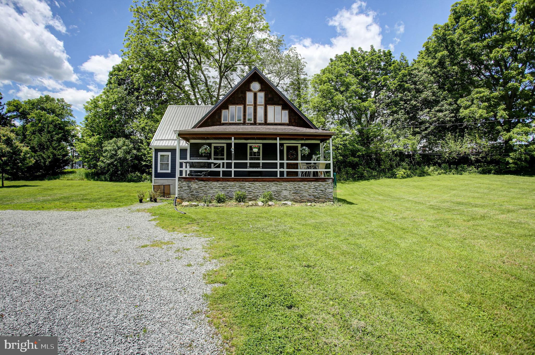 A-frame homes don’t come along often—especially on nearly 2 acres in the heart of historic Mercersburg.

Tucked away at the end of a private lane, this one-of-a-kind 3-bedroom, 2-bath home offers the perfect combination of architectural charm, modern comfort, and peaceful country living. A welcoming covered front porch invites you to slow down and enjoy the tranquil setting, whether you’re sipping your morning coffee or relaxing after a long day.

Inside, soaring cathedral ceilings and an open-concept layout create an airy, inviting atmosphere. The spacious living area is anchored by a beautiful stone fireplace, adding warmth and character to the home’s distinctive design. The kitchen features concrete countertops, stainless steel appliances, and a large pantry, making it as functional as it is stylish.

The main level offers two bedrooms, a full bath, and a generous laundry room with ample storage. Upstairs, the private primary suite feels like a retreat of its own, complete with a sitting area, large closet, and spa-inspired bathroom beneath vaulted ceilings.

Outside, nearly 2 acres of level lawn and mature trees provide space to entertain, garden, play, or simply enjoy the privacy and beauty of your surroundings. Rarely does a property offer this much character, space, and serenity in such a convenient location.

Ready to relax and unwind? Schedule your private tour today.