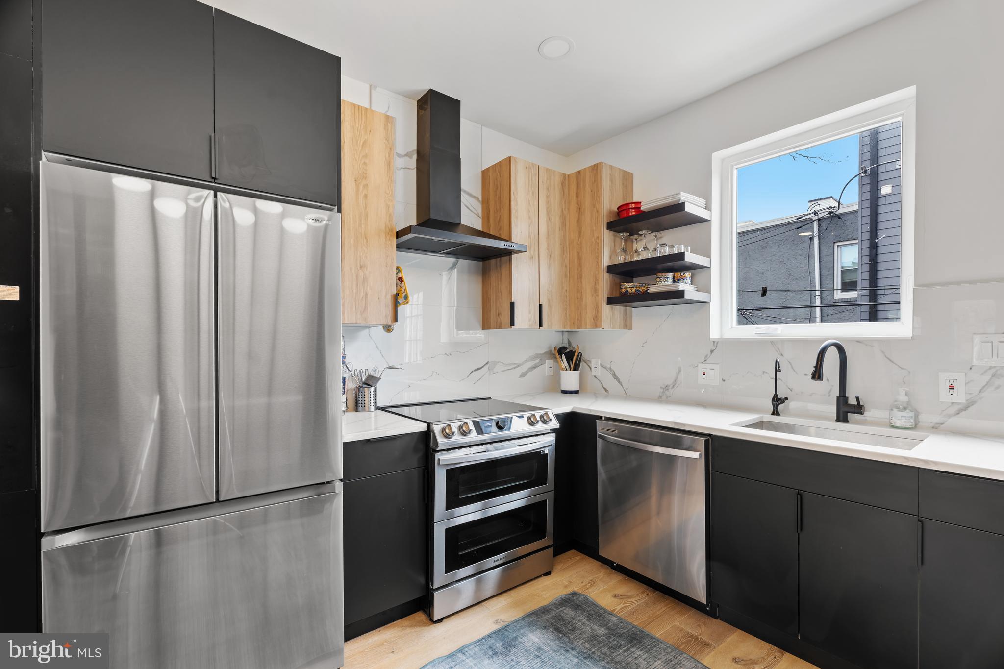 Welcome to this beautifully customized newer construction townhome on a fantastic block in Brewerytown. Just 3 years young, this exceptional 3-bedroom, 3-bath home offers the perfect blend of modern design, thoughtful upgrades, and incredible outdoor living. Step inside to find gorgeous hardwood floors, oversized sun-filled windows, and stylish finishes throughout. The third-floor primary suite is a true retreat, featuring a walk-in closet, private bath, and its own balcony, with interior access leading to a stunning rooftop deck—perfect for relaxing or entertaining. The second floor offers two bright bedrooms, a full hall bath, and convenient second-floor laundry. Downstairs, the finished basement with soaring ceilings and a full bath provides ideal space for a guest suite, home office, gym, or media room. Enjoy three outdoor spaces, including a spacious private rear yard, offering rare outdoor living in the city. The kitchen has been fully upgraded beyond builder-grade finishes, and the home also features custom electric blinds throughout for added comfort and style. As an added bonus, the seller is offering the option to purchase the home fully furnished, making this an incredible turnkey opportunity. A truly special home that combines luxury, comfort, and location—schedule your showing today. All outdoor plants and furnishings included in the sale.