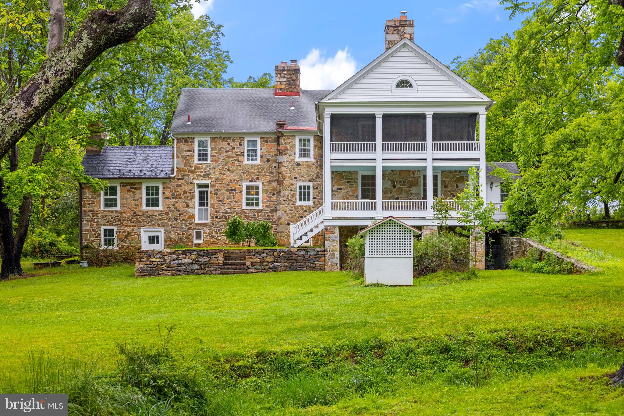 Welcome to Greystone – A Living Piece of Virginia History. 


Nestled in the heart of historic Waterford, Greystone is a rare 18th-century stone home offering nearly 300 years of rich heritage, enduring craftsmanship, and timeless elegance. With 7 bedrooms, 1.5 finished bathrooms, and 3 additional full bathrooms in place but not yet completed, providing opportunity for customization. 


Spanning  6,500 finished square feet, this residence offers grand scale and character. Built in phases across three centuries, this architectural treasure began as a modest fieldstone cottage (circa 1735) and has evolved into a distinguished estate that embodies the soul of colonial and early American history.


The original one-up, one-down structure, with hand-hewn oak beams, wood-paneled library, and massive fireplaces, remains a focal point of character and authenticity. In the early 1800s, a Georgian-style wing expanded the home’s footprint. In 1915, renowned Washington architects designed the Arts & Crafts–inspired Lodge Room, along with elegant formal rooms and multiple expansive porches for entertaining. Woodwork throughout was crafted to echo the home’s early American roots.


Recent improvements, totaling over $650,000, have carefully preserved Greystone’s historic charm while modernizing its infrastructure and enhancing its livability.


Included in the sale is permanent membership to the Greystone Pool, historically the first public-use pool in Loudoun County and still beloved by the community today. Across the road lies the original pool and old tennis court site, once host to neighborhood gatherings.


Greystone sits on a generous parcel of over 53 acres offering breathtaking views and a wonderful opportunity to own a true piece of Virginia’s past. Also on the property is a small charming cottage, detached 2-car garage, greenhouse and an improved granary. And NO HOA!


Whether you're drawn to its distinguished provenance, its historic detailing, or the chance to make your own mark on a property rich with stories, Greystone invites you to become the next steward of its legacy.