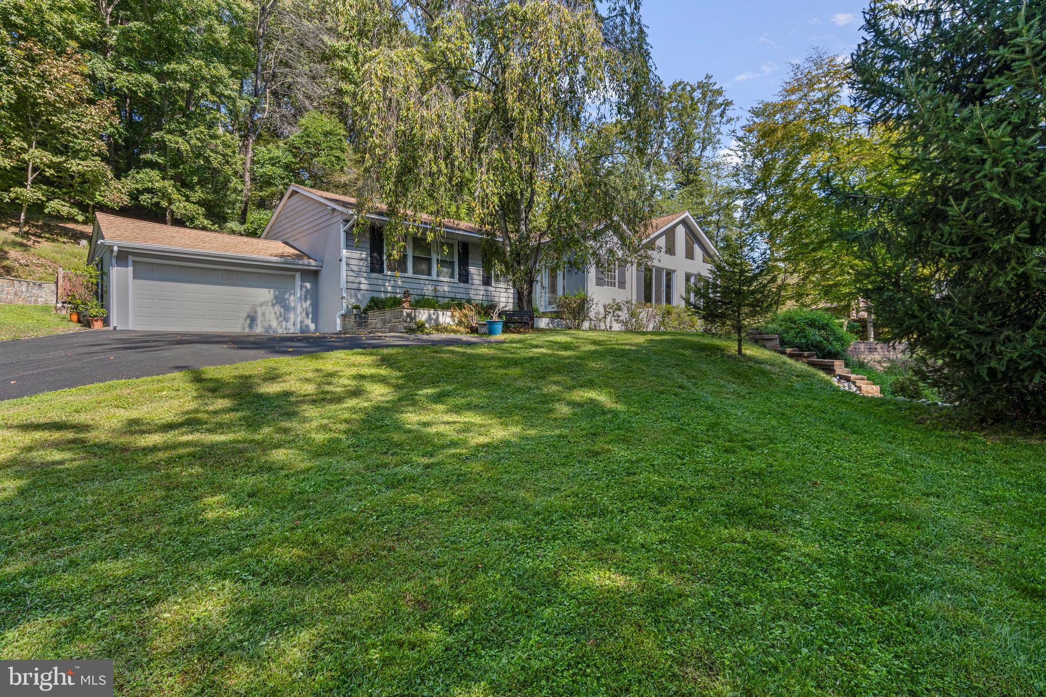 Welcome to your private retreat in Glen Mills —A rare hidden gem that blends luxury, privacy, and functionality. Enter through the double-gated driveway, past the serene fish pond and fountain, into a natural paradise bordered by 150 acres of wetland preservation and 25 acres of historic preservation. This one-of-a-kind property sits on over 7 acres in the award-winning Garnet Valley School District, just minutes from shopping, dining, major routes, and the airport. The main residence offers more than 3,500 sq. ft. of living space. A welcoming foyer opens to a dramatic sunken living room with soaring 15’ cathedral ceilings, a floor-to-ceiling stone fireplace with wood-burning insert, custom black walnut shelving, dual fans, skylights, and abundant natural light. French doors lead to an entertainment room with vaulted transom windows, the perfect spot to enjoy wildlife and a natural spring. At the heart of the home is the chef’s kitchen, featuring custom cabinetry, upgraded appliances, a built-in workstation, and an expansive two-tier granite island with 13’ of counter space. An attached sunroom/greenhouse provides a bright sitting area or year-round growing space. The private primary suite showcases floor-to-ceiling windows, dual walk-in closets, and a spa-inspired en-suite with heated travertine floors, Jacuzzi tub, and multi-spray digital shower. Three additional bedrooms with oversized closets (one cedar) and a beautifully renovated hall bath complete the opposite wing of this amazing 1 story rancher. A finished half-basement with new carpet, a dry bar, and ample storage connects to the oversized two-car garage, which features a mechanics pit for car enthusiasts. Outside, enjoy the expansive stamped-concrete patio and separate firepit area ideal for entertaining. A natural spring flows into a babbling brook with three custom bridges and a hand-built retaining wall adds to the property’s charm. A major highlight is the 2,300 sq. ft. heated Class C building with half bath, currently used as a business workshop. This versatile space offers endless potential — from a car collector’s dream to guest quarters. A covered exterior area provides storage for equipment and firewood, while a fully floored and insulated attic expands capacity. Additional upgrades include a wood-burning system that heats both the shop and the entire home with portions of the home having radiant heat floors, whole house & 2nd building backup generator, newer roofs on both structures, energy-efficient windows, new driveway and fencing with dual entry gates, and plentiful parking for large gatherings. Amazing wildlife. Bow Hunting allowed on the property. New Septic system (2021) This is a 100% turnkey property. This remarkable property combines privacy, luxury, and functionality — offering the best of country living with easy access to modern amenities.  Your home will be the talk of everyone who visits. All of this in the highly desired school district of Garnet Valley. Minutes to all major routes, plenty of shopping and dining options. *Other items possibly available with the property for purchase include an upgraded golf cart, a top-tier quad vehicle, three riding mowers, a log splitter, a mini backhoe, chainsaws and much more. You simply must see this property in person. If interested, a private tour of the entire grounds with the owner can be arranged. * Seller may include items at sellers discretion. **Seller may credit the buyer to have the second driveway resurfaced. *** The property does NOT require flood insurance as per the seller.