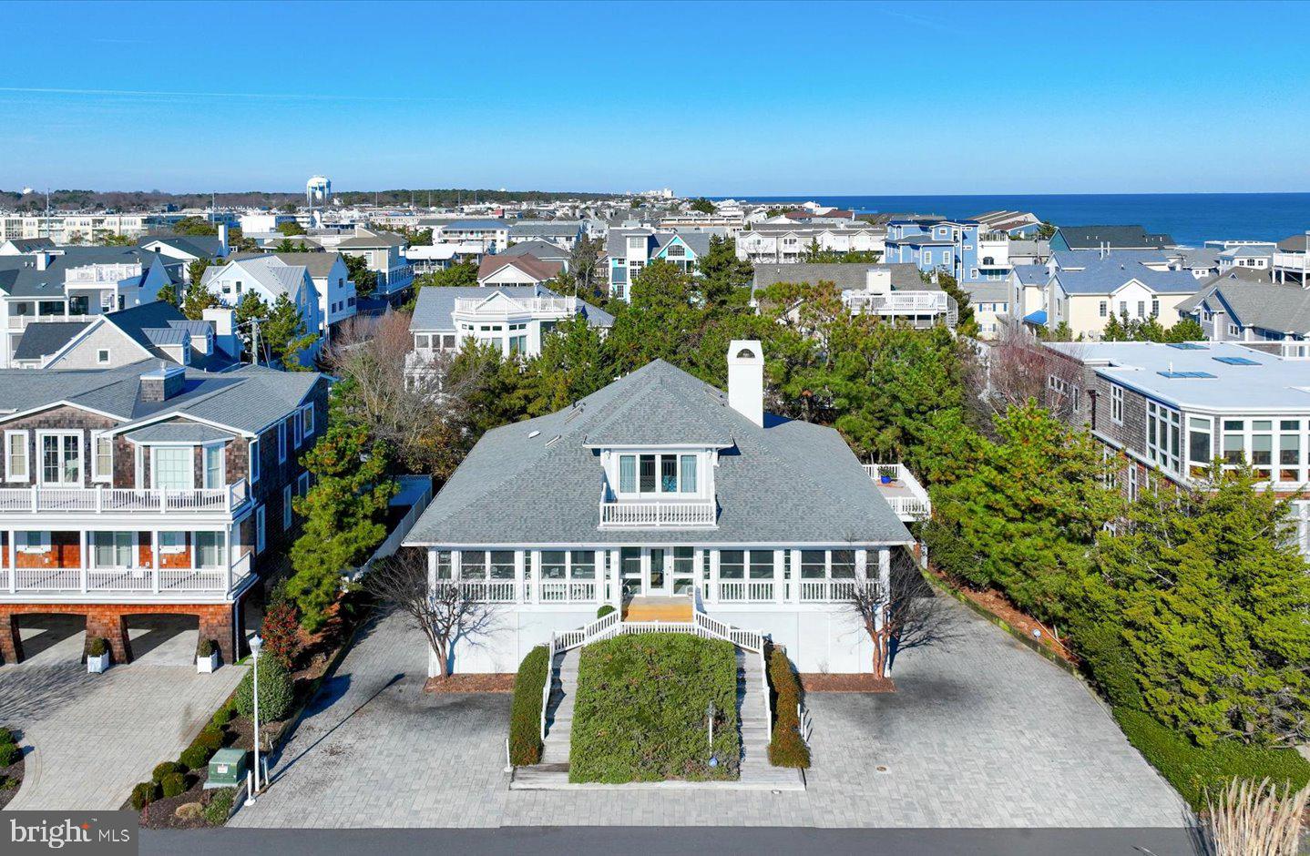 Imagine a coastal lifestyle defined by uncrowded sands, gentle ocean breezes, and the rhythmic sound of the surf—all just steps from your door. Ideally located in the highly coveted Indian Beach community, just south of Dewey Beach, this exceptional coastal residence was thoughtfully designed to embrace the very best of beach living. Outdoor living is a defining element of the home, with multiple sun decks, balconies, and a spacious wraparound screened porch that invite relaxation and connection to the outdoors. Whether enjoying morning coffee, evening sunsets, or casual gatherings with family and friends, these spaces create a seamless extension of the interior living areas. Inside, hardwood floors and a well-designed layout provide a comfortable and natural flow throughout the home. Multiple living spaces offer flexibility for both everyday living and entertaining, including a cozy den, a generous living room, and an inviting keeping room. The kitchen is ideally suited for hosting, featuring a commercial-grade refrigerator, large center island, and dual ovens, and it opens effortlessly to both the formal dining room and a casual outdoor dining area. Two beautifully appointed guest bedrooms feature en-suite baths, offering privacy and comfort for visitors. The cozy den with an attached full bath provides additional flexibility and may serve as a fourth bedroom. The entire third level is dedicated to the private primary suite, a true retreat featuring vaulted ceilings, skylights, dual custom closets, a comfortable sitting area, and a spa-like en-suite bath with dual vanities and a soaking tub. From the private sun deck, enjoy open views and spectacular sunsets over Rehoboth Bay. Additional highlights include an elevator, a one-car garage ideal for beach gear, covered parking, and a prime coastal location. A classic beach home in a sought-after community, this is a rare offering for those seeking refined coastal living at its finest.