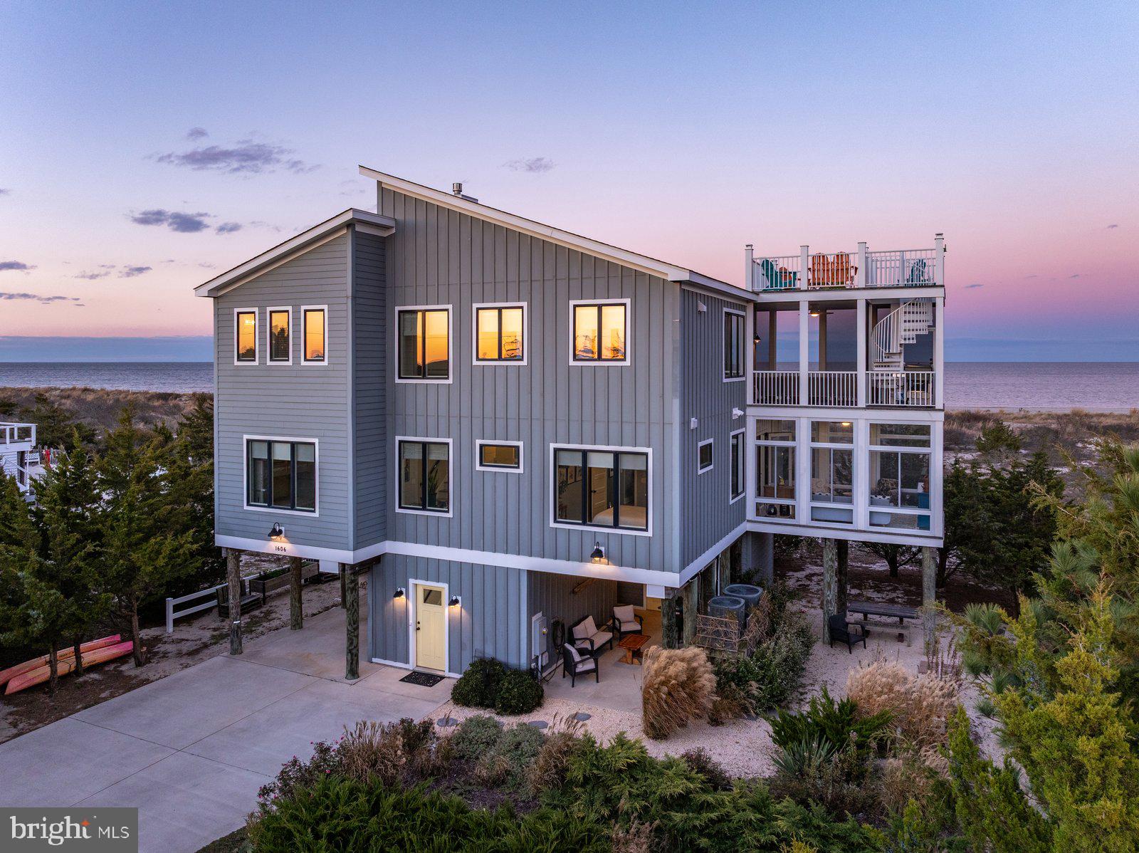 A Bayfront Sanctuary Where Every Sunrise and Sunset Steals the Show

Welcome to your private coastal retreat—where modern luxury meets timeless tranquility. Perfectly positioned on the serene shores of Broadkill Beach, this 2017 custom-built bayfront residence captures the essence of waterfront living with sweeping 360° views, seamless indoor-outdoor design, and elegant, sun-filled interiors.

Wake up to the sound of gentle waves and golden light reflecting off the Delaware Bay. Step onto one of your many balconies with coffee in hand as dolphins glide by in the distance, or gather with friends on the roof top deck and beach, as the evening sky transforms into shades of coral and violet over the refuge. Every level of this home is thoughtfully designed to frame the beauty of the bay—offering sunrise and sunset views that change with each season, yet always inspire awe.

Inside, over 3,000 square feet of refined coastal architecture await. With 5 spacious bedrooms and 3.5 bathrooms, this residence offers both intimate family comfort and open spaces ideal for entertaining. The inviting great room centers around a spectacular stone fireplace and flows effortlessly to multiple decks—perfect for savoring the views and sea breeze.

The chef’s kitchen is a coastal showpiece, featuring high-end finishes, custom cabinetry, and an expansive island—ideal for hosting brunches or sunset dinner parties. Every detail, from designer lighting to thoughtfully curated flooring, reflects a commitment to quality, sophistication, and effortless seaside living.

Outside, the 75X100 landscaped lot has been artfully designed for both beauty and function, with premium side yards, secure storage, an outdoor shower, and extensive hardscaping that complements the home’s natural surroundings. A concrete driveway with space for six vehicles ensures ample room for guests eager to share in your waterfront lifestyle.

Just steps away, the sandy beach invites morning walks, paddleboarding, or kayaking across the calm bay waters. As night falls, ascend to your private rooftop deck to stargaze beneath an endless coastal sky—a signature Broadkill Beach experience found only in homes of this caliber.

Whether as a primary residence or a luxury coastal escape, this rare offering promises more than a home—it delivers a lifestyle defined by peace, beauty, and connection to the water.

Sellers are open to negotiating the purchase of the brand-new Kawasaki Beach Buggy, paddleboards, kayaks, and Sunfish on a separate bill of sale making for instant beach enjoyment and fun memories in the sun.