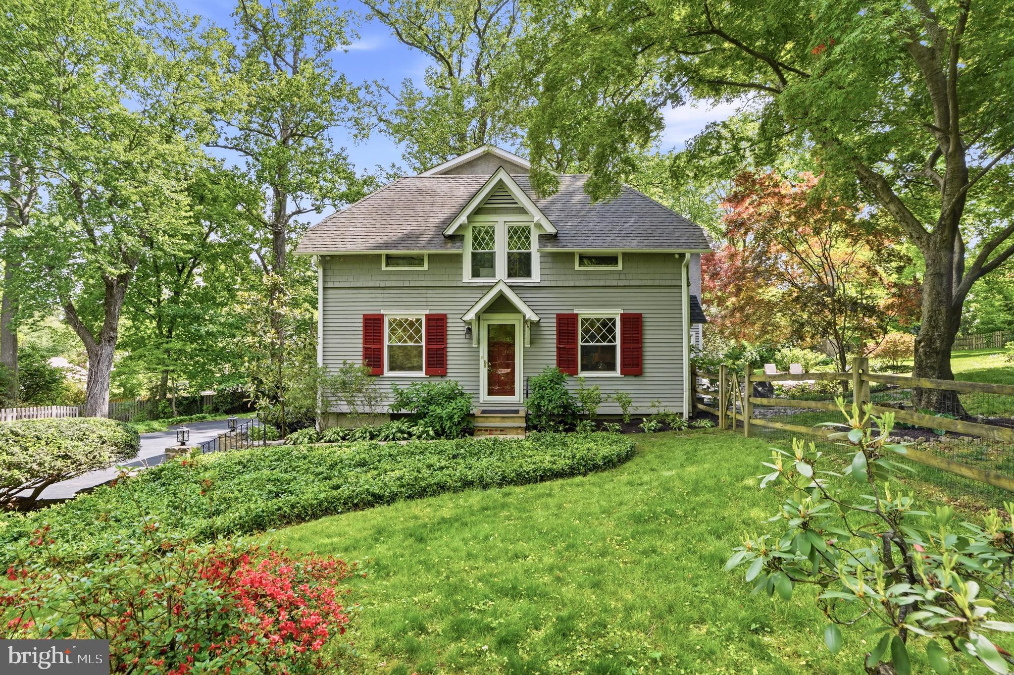 Tucked away in the heart of Villanova, 211 Comrie Drive is a garden retreat unlike anything else on the market. Originally a carriage house on the Hardwicke Estate, this one-of-a-kind home has been thoughtfully reimagined with 5 bedrooms, 3 full baths, several versatile bonus rooms, and over 3,700 square feet. A long private driveway leads to a generous parking area with room for 9+ cars, setting the tone for a home that is both charming and highly functional. Inside, the main level offers an updated kitchen with rich wood cabinetry, a large center island, stainless steel appliances, and easy connection to the dining and living areas. The standout family room is wrapped in diamond-pane windows, framed by a dramatic 15-foot tray ceiling, and opens through French doors to the rear garden. A bedroom, full bath, laundry, and an additional room currently used as an office add flexibility for guests, work, or everyday life. Upstairs, four additional bedrooms include a comfortable primary suite with walk-in closet and double-vanity bath, along with well-sized secondary bedrooms and additional full baths. The lower level extends the home’s versatility with a finished recreation room, large mudroom with built-ins, and generous storage. The outdoor setting is the soul of the property: fully fenced and surrounded by mature trees, layered landscaping, stone walls, open lawn, and tiered patios, the rear yard feels like a lush escape designed for quiet mornings, summer dinners, entertaining, and play. Set along a quiet Radnor Township street close to The Agnes Irwin School, Villanova University, and the conveniences of the Main Line, 211 Comrie Drive offers estate history, modern livability, and a rare sense of seclusion in a truly special Villanova setting.