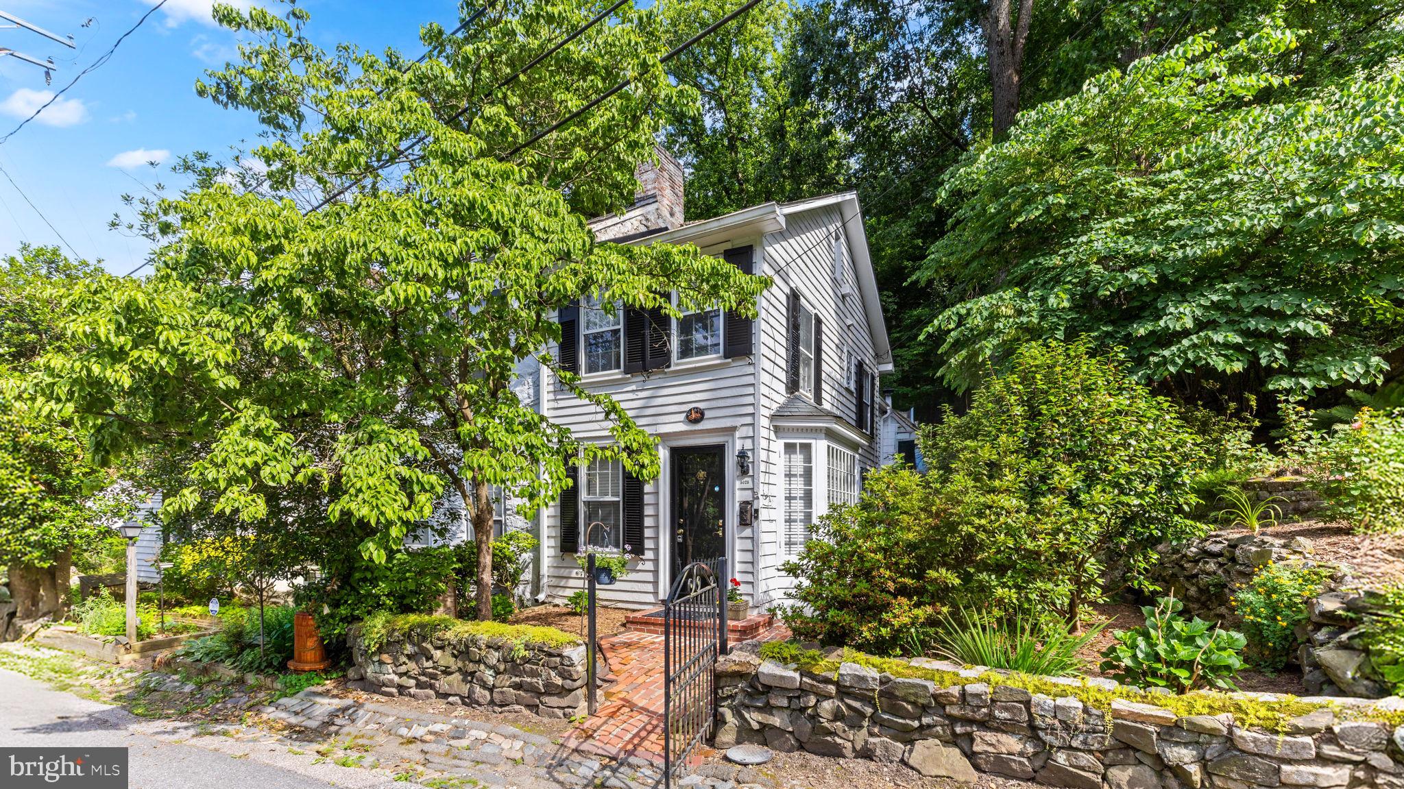 Welcome to 5025 Wetheredsville Rd, nestled in the heart of the historic Dickeyville Historic District, one of Baltimore’s best-kept secrets and truly one of the city’s most charming hidden gems. This unique community offers the perfect blend of historic character, natural beauty, and modern convenience, creating a peaceful retreat that feels worlds away while remaining just minutes from downtown Baltimore.

Enjoy being walking distance to Maryland’s newest state park, the breathtaking 1,200-acre Gwynn Falls State Park, where miles of scenic trails, lush forest, and protected green space provide endless opportunities for hiking, biking, birdwatching, and reconnecting with nature. The area is rich with wildlife, and it’s common to spot foxes, deer, raccoons, and a wide variety of beautiful songbirds right from your own backyard.

Surrounded by mature trees and scenic walking trails, this home offers a rare “country setting with city access” lifestyle that is incredibly hard to find anywhere else in Baltimore. The outdoor living space is truly exceptional, featuring extensive hardscaping, two wood-burning outdoor fireplaces, and a spacious rear yard backing to woods and greenery, perfect for entertaining, relaxing under the stars, or simply enjoying the peaceful natural surroundings.

Inside, the home is filled with warmth and character, showcasing beautiful hardwood flooring, original exposed stone walls throughout the home, timeless architectural details, and thoughtful updates throughout. Recent improvements include a newer roof, new custom refrigerator, and new electric oven/range. The property also offers abundant storage space and surprisingly low electric bills, helping keep monthly utility costs affordable.

Residents of Dickeyville enjoy access to a close-knit historic community with a voluntary HOA of only $90 per year. Qualified buyers may also benefit from available grants and incentives, making this an incredible opportunity to own a home in one of Baltimore’s most unique and sought-after neighborhoods.

Don’t miss your chance to own a piece of Dickeyville and experience the rare combination of history, nature, community, and convenience that makes this neighborhood so special.