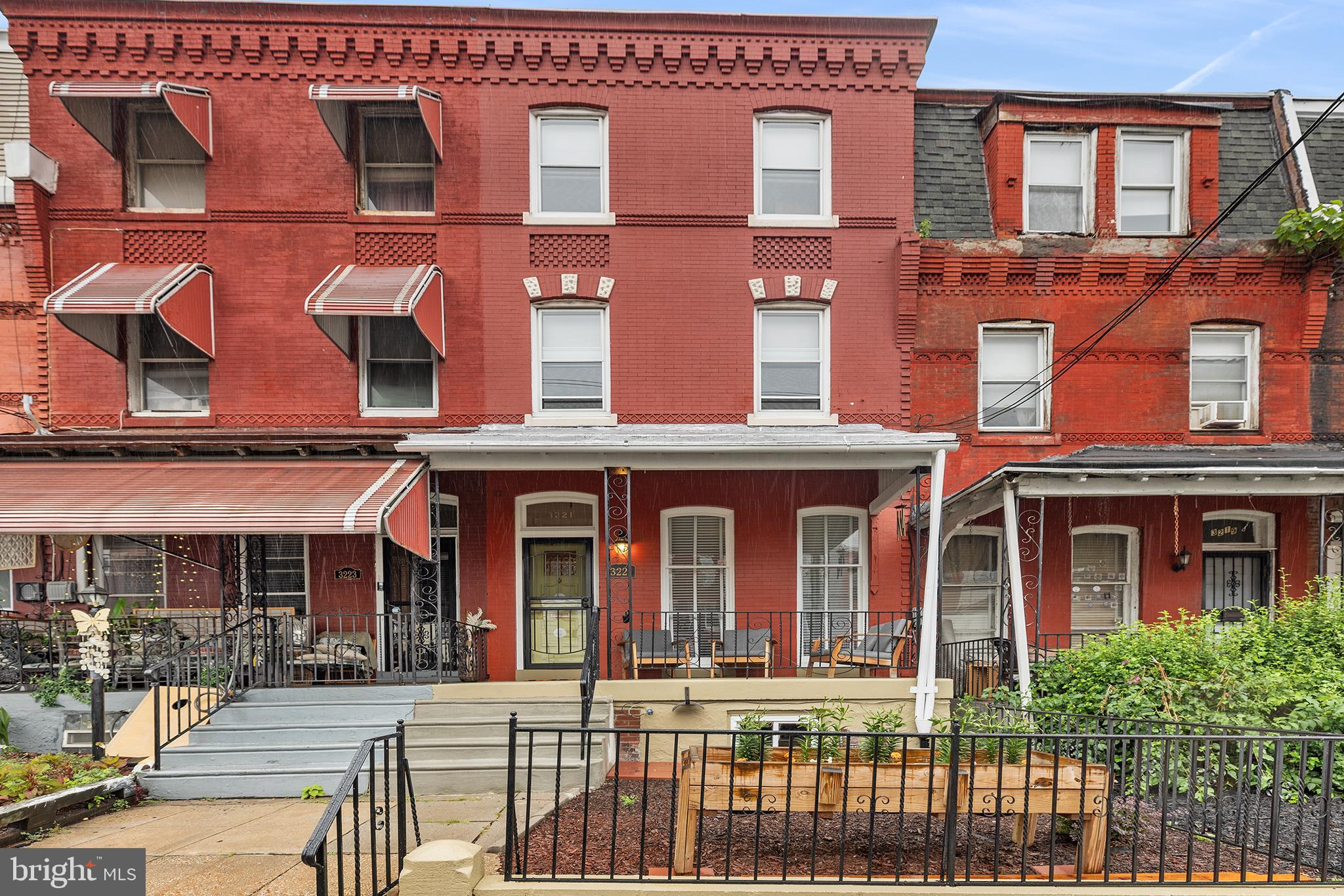 More than just a large University City rowhome, 3221 Haverford Avenue is a home that has been thoughtfully stewarded. Over the years, the owners carefully restored original pine doors and hardware, refinished historic details, and maintained the property with an eye toward preserving its character while providing a comfortable home for their children during their college and early professional years. The result is a rare blend of vintage Philadelphia craftsmanship and true move-in-ready condition.  Rich with original architectural details, this classic West Philadelphia residence showcases decorative brickwork, a handsome cornice, stained glass, checkerboard tile vestibule, restored pine doors, original wood floors, and vintage mantels that speak to the home's enduring craftsmanship.  A freshly painted covered front porch overlooks a generous front garden and leads into a bright parlor-style living room highlighted by nearly floor-to-ceiling windows. The main level also offers a formal dining room, updated powder room, and an efficient kitchen featuring stainless steel appliances and an exposed brick hearth. A rear mudroom provides valuable pantry and storage space before opening to a sunny elevated patio with pavers and planting beds.  The second floor includes three generously sized bedrooms and a full bath, while the third floor offers two additional bedrooms and another full bath. The front third-floor bedroom enjoys sweeping southern views of the Center City skyline, while the rear bedroom retains charming reminders of the home's history, including an antique sink from a former kitchenette.   The unfinished basement is simply large, dry, and clean with excellent headroom.  Conveniently located close to Penn, Drexel, CHOP, Penn Medicine, 30th Street Station, the Art Museum area, and major commuter routes including I-76, this is an exceptional opportunity to own a substantial five-bedroom Philadelphia home in one of the city's most connected neighborhoods.  Think old-house charm without old-house headaches.  Easy to show and a pleasure to see.