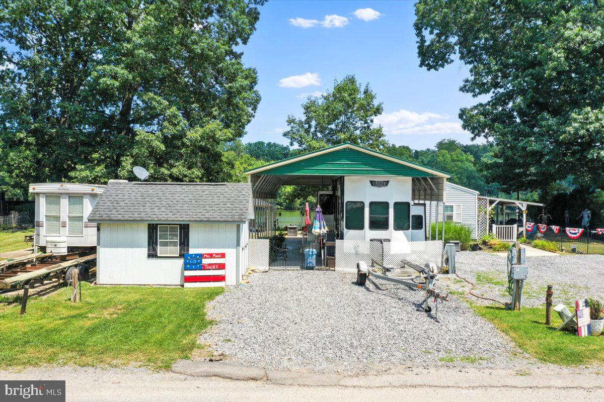 Make your riverfront dreams come true with Lot 1-27 in River Bend Park! This riverfront lot comes fully equipped with a luxury 2022 RV, private dock, pontoon boat, pavilion, shed, golf cart, outdoor kitchen, furniture, and lush landscaping—everything you need for the ultimate summer escape. Located in the gated, seasonal River Bend Park community (open April 1–November 1), ownership includes access to amenities like bath houses, laundry facilities, a camp store, sports courts, miniature golf, a restaurant, and more. Annual dues of $1,775 cover electricity, water, trash, pump-outs, and community amenities. Visitors must check in at the guard shack and be accompanied by an agent or lot owner. Just bring your swimsuit—this one’s ready to enjoy!