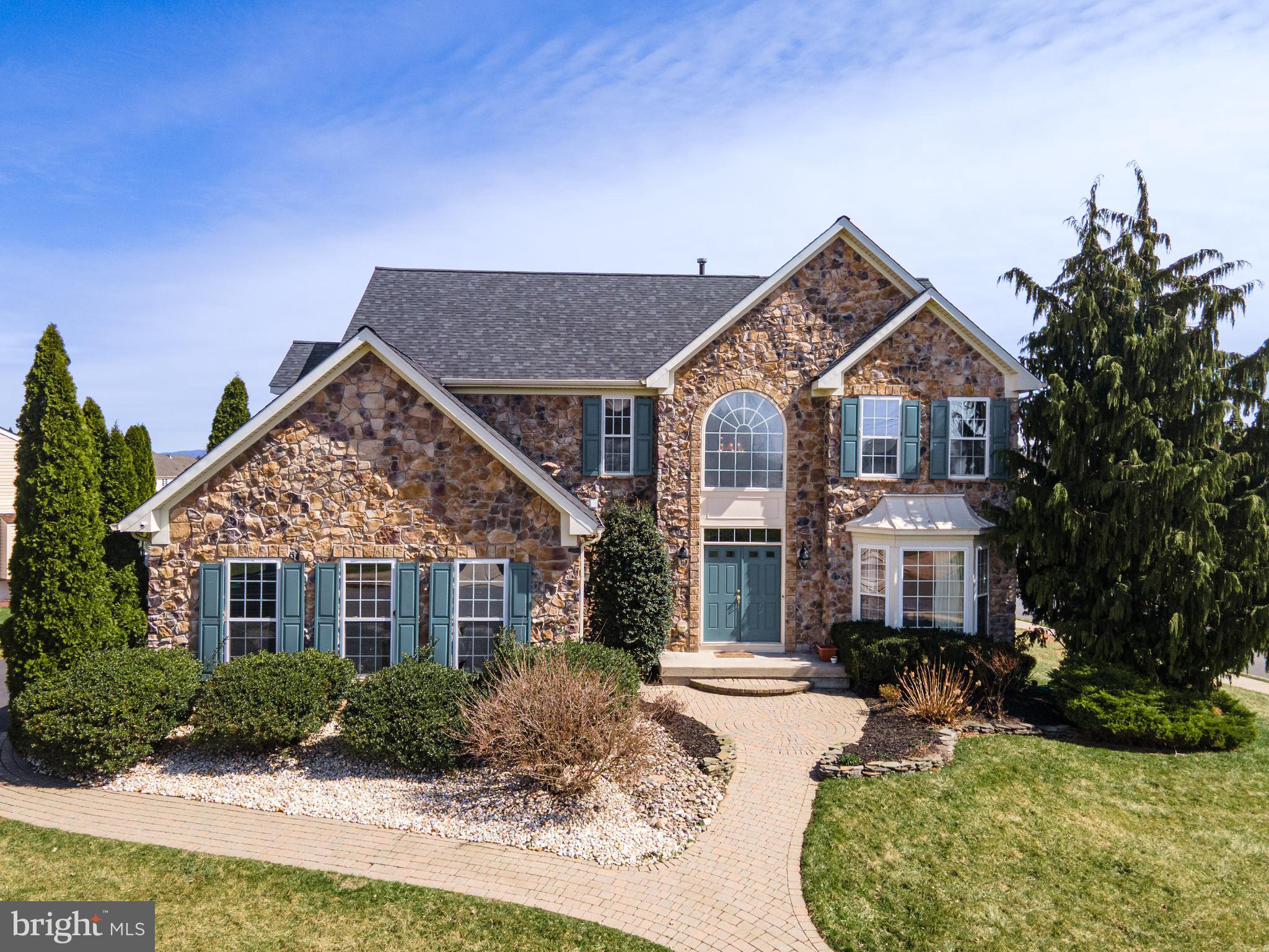 Welcome to this stunning 4-bedroom, 2 full and 2 half bath Colonial with brand NEW ROOF and newly painted, perfectly situated on a desirable corner lot and highlighted by an impressive full stone façade. A grand entrance with double doors opens into a dramatic 2-story foyer featuring a large Palladian window and elegant chandelier. Refinished Hardwood floors flow seamlessly from the foyer into the formal living and dining rooms, both enhanced by bump-out windows, crown molding, chair rails, shadow boxes, and refined baseboard trim. The beautifully updated kitchen is a chef’s dream, complete with stainless steel appliances, double wall ovens, recessed lighting, granite countertops, a double-door pantry, and an oversized center island with built-in range. Just beyond, the sunroom offers a bright and inviting space with a cathedral ceiling, skylights, and ceiling fan. The cozy family room features new wall-to-wall carpeting, recessed lighting, built-in speakers, and a gas fireplace with mantel and accent spotlights—perfect for relaxing or entertaining. A convenient laundry/mudroom and powder room complete the main level. Upstairs, double doors lead to the luxurious primary suite with new HW flooring, a vaulted ceiling, chair rails, ceiling fan, built-in speakers, a spacious walk-in closet, and a private sitting area. The en-suite bath boasts dual sinks, tile flooring, a tiled jetted corner tub, a tiled walk-in shower with glass door, and a private commode. Three additional bedrooms with new hardwood floors share a full bath with tile flooring and a tub/shower combo. The fully finished daylight basement expands your living space with updated luxury vinyl plank floors, recessed lighting, and chair rail detailing, along with a dedicated media room featuring built-in speakers and a raised platform—ideal for movie nights. A half bath adds convenience to this level. Step outside to the deck overlooking a level backyard, offering the perfect setting for outdoor entertaining or quiet relaxation. Conveniently located close to major highways US-22 and PA-33 for easy commute, Palmer Mall, Morgan Hill and Sawmill Golf Courses, shopping, restaurants and so much more!