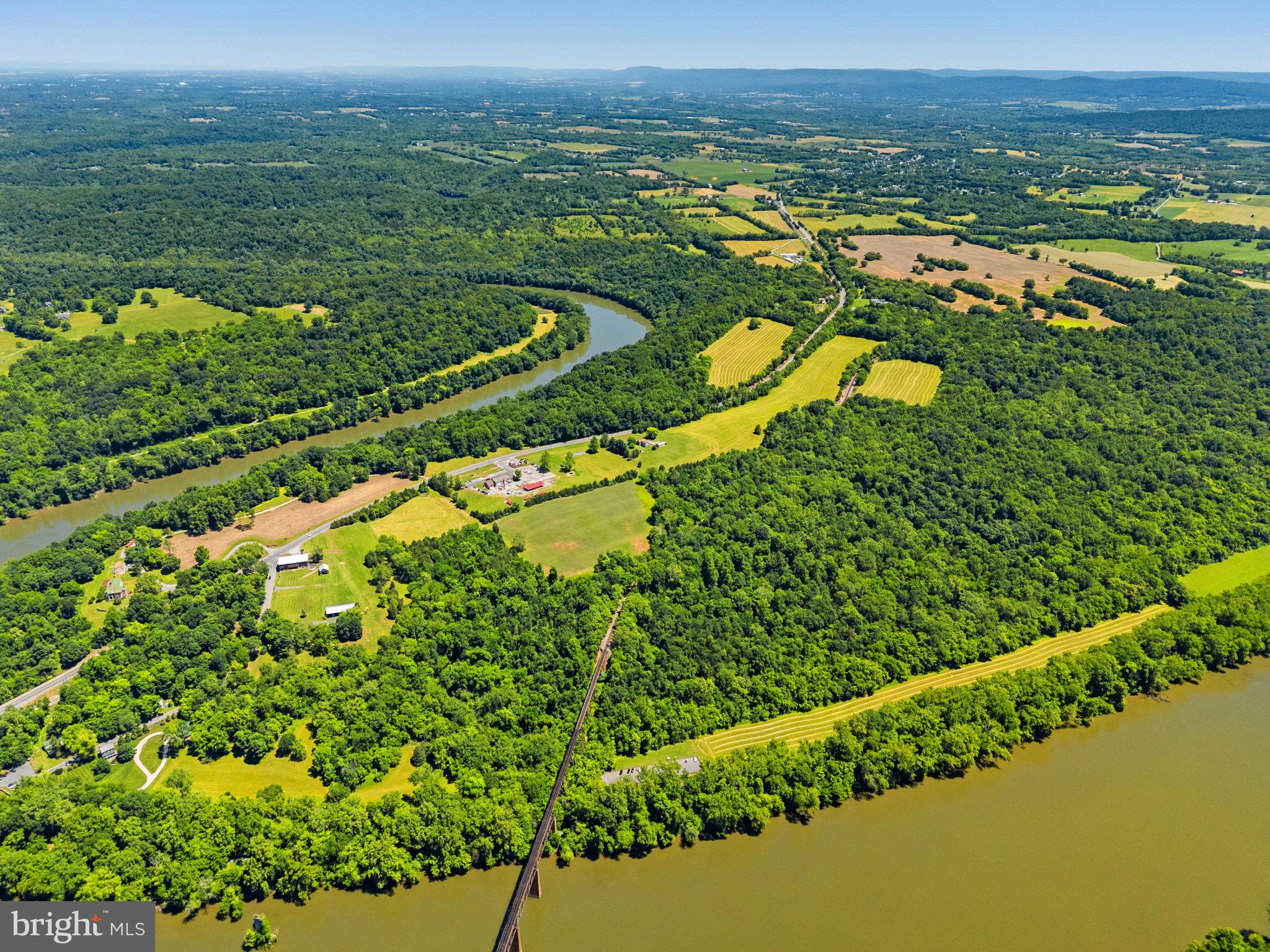 Nestled along one of the most scenic stretches of the Potomac River and available for the first time in over 70 years, 16318 Canal Road presents a rare opportunity to own approximately 138 acres of preserved agricultural land in the heart of historic Washington County. Featuring over 2,000 feet of frontage along both the Potomac River and the renowned C&O Canal Towpath, this remarkable property offers an exceptional combination of natural beauty, recreational access, privacy, agricultural utility, and long-term investment appeal. Complementing the property's extraordinary acreage is an established homesite that includes a well-maintained brick rancher, detached garage, and outbuildings. A particularly notable feature is the property's historic circa-1820 bank barn, a striking architectural landmark that reflects the rich agricultural heritage of the Potomac Valley. The gently rolling landscape unfolds across open fields and mature woodlands, descending to picturesque riverfront scenery. Outdoor enthusiasts will appreciate direct access to the iconic C&O Canal Towpath, a destination known for miles of hiking, biking, horseback riding, fishing, and birdwatching along the Potomac River. The property's extensive river frontage provides a front-row seat to the region's changing seasons and abundant recreational opportunities. Beyond its agricultural and recreational value, the property's scale, setting, and waterfront location present compelling opportunities for future stewardship and creative uses. The combination of open farmland, wooded acreage, river access, and proximity to major metropolitan areas may appeal to those envisioning a multi-family residential neighborhood, private family compound, agritourism venture, destination wellness or corporate retreat, or hospitality use. Approximately 15 acres along the Potomac River lie within the natural floodplain and are protected by a scenic easement, preserving the property's most spectacular waterfront landscape. This protected corridor enhances ecological value and safeguards the scenic character and open vistas that define this exceptional setting. The combination of preserved riverfront acreage, extensive water frontage, and direct access to the C&O Canal Towpath creates a rare recreational and conservation asset while helping maintain the property's long-term natural beauty. Despite its peaceful setting, the property is just minutes from downtown Sharpsburg, a charming historic town known for its small-town character, local shops, restaurants, community events, and proximity to Antietam National Battlefield. The area's rich Civil War heritage and scenic countryside further enhance its appeal. Within walking distance are Potomac Ridge Brewing and Little Brick Coffee, popular local gathering places that contribute to the area's growing reputation as a destination for outdoor enthusiasts and weekend travelers. Equally convenient is nearby Shepherdstown, one of the region's most desirable destinations. Home to Shepherd University, Shepherdstown offers a vibrant arts and culture scene, acclaimed dining, boutique shopping, galleries, live music, and year-round festivals. Its historic downtown and strong local business community make it a favored river town throughout the Mid-Atlantic. Ideally situated within easy reach of Washington, D.C., Baltimore, Northern Virginia, and the surrounding tri-state region, this extraordinary property combines accessibility with remarkable seclusion. Whether envisioned as a working farm, recreational retreat, or long-term legacy property, 16318 Canal Road offers a rare opportunity to own a significant piece of Western Maryland’s natural and historic landscape.