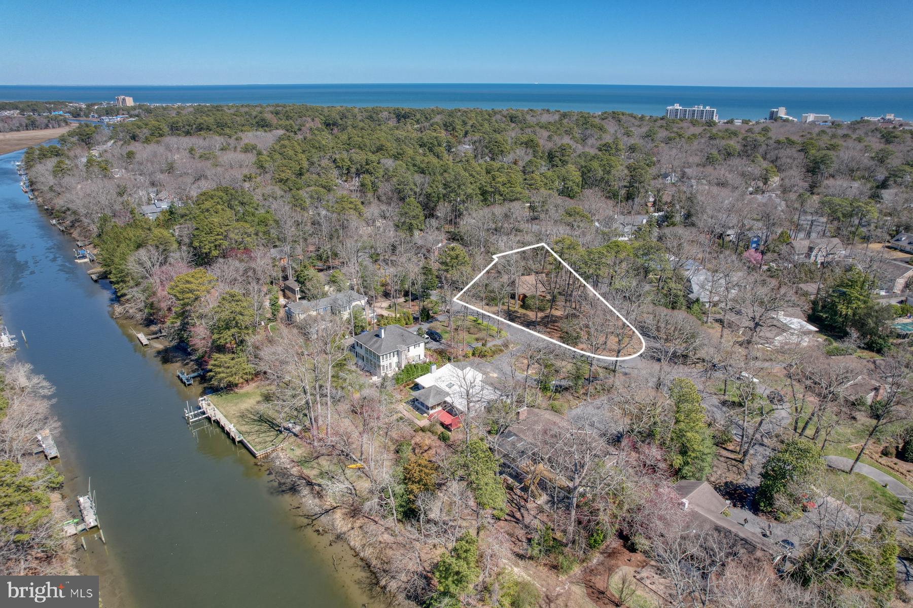 Welcome to Henlopen Acres – A Rare Offering Between the Canal and the Beach!

Set on a rare, private half acre triangular peninsula style lot between the Lewes-Rehoboth Canal and the Atlantic Ocean, this stunning contemporary residence is nestled on a spacious, wooded lot just blocks from the beach. Offering the perfect blend of privacy, comfort, and coastal charm, this unique home is a rare find in one of the area's most coveted neighborhoods. 

This distinctive, three-sided lot resembles a peninsula and is outlined by natural tree cover and set apart by its generous triangular shape, offering a rare sense of seclusion and privacy on all sides.  There is Town of Henlopen Acres property located around this lot that can not be built on, and offers an even more private setting.  

Step inside to discover a light-filled, open-concept great room, where vaulted ceilings, rich wood accents, and dramatic floor-to-ceiling windows frame serene views of the surrounding forest. Hardwood floors and a freestanding wood-burning stove add warmth and character to this inviting space.

The great room flows seamlessly into the dining area, complete with exposed wood beams and hardwood flooring. Sliding glass doors open to a generous outdoor patio featuring a cozy fire pit—ideal for entertaining or unwinding in nature.

The well-appointed kitchen features crisp white cabinetry, quartz countertops, propane cooking, and luxury vinyl plank flooring. A charming eat-in nook with built-in bookshelves adds a homey touch, and offers convenient access to both the laundry area and powder room.

The three-season room is perfect for year-round relaxation, with ample windows to capture ocean breezes and baseboard heating to keep things cozy in cooler months.

The home’s thoughtful layout includes two spacious first-floor bedrooms with hardwood floors, wood beam ceilings, and a shared hallway bathroom. Upstairs, a private ensuite bedroom offers a large closet and tranquil treetop views.

On the lower level, you’ll find a walk-out two-car garage with an outdoor shower—perfect after a day at the beach—as well as a mechanical/workshop space and a bonus room with built-in bookshelves, ideal for games or hobbies.

Outdoors, enjoy a nature lover’s paradise with mature landscaping, multiple seating areas, and scenic walking paths perfect for birdwatching, gardening, or quiet reflection.

Featuring a new HVAC system, new washer and dryer, invisible pet fence, & much more. 

Residents of Henlopen Acres enjoy exclusive access to a private beach and the option to join the Henlopen Acres Beach Club, which includes a clubhouse, tennis courts, and beach chair and umbrella service. Boat enthusiasts can also take advantage of the community’s private marina—perfect for fishing, canal cruising, and coastal exploration.

Art lovers will appreciate being just moments away from the Rehoboth Art League, offering year-round classes, exhibits, and cultural events.

Whether you're searching for a peaceful year-round residence or a sophisticated weekend retreat, this exceptional property combines timeless design with unbeatable location. Don’t miss your chance to own a one-of-a-kind home in the heart of Henlopen Acres. Take the video tour!