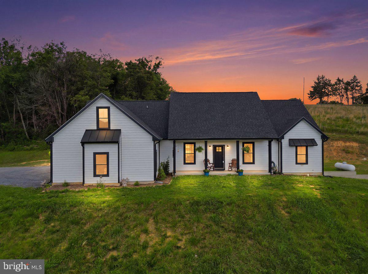 Welcome to your own private retreat in the heart of the Shenandoah Valley! Built in 2022, this like-new custom home blends modern farmhouse style with luxury finishes, mountain views, and endless flexibility for today’s lifestyle. The striking white siding with bold black windows and trim create unforgettable curb appeal, while the peaceful setting on a non-through road offers the privacy you’ve been searching for.

Step inside to an open-concept main level filled with natural light, soaring vaulted ceilings, and oversized windows stretching across the back living and dining area. A stunning gas fireplace anchors the space, while the designer kitchen features, soft-close cabinetry, custom quartz countertops, abundant cabinet space with slide out draws, smart siding, custom awnings, and room to gather and entertain with ease.

Just beyond the main living area, enjoy the covered rear porch with metal roofing — the perfect place to unwind with your morning coffee, listen to the rain, hang flower baskets or hummingbird feeders, or even create your dream screened-in outdoor living space. Out front, the covered porch showcases breathtaking mountain views that truly capture Shenandoah Valley living.

The primary suite is a dream retreat featuring an oversized bedroom, expansive walk-in closet with custom built-ins, and a luxurious spa-inspired bath complete with a soaking tub with a view, tiled shower with blue tooth capability, and glass doors. On the opposite side of the home, you’ll find three additional bedrooms with large closets, including a second bedroom suite with its own ensuite bath and beautifully tiled tub/shower surround.

Upstairs offers incredible flexibility and could easily function as a private in-law suite, guest retreat, game room, home business setup, homeschool area, office, craft room, studio, or multi-generational living space. With an additional room and full bath, the possibilities are endless.

Additional features include an attached garage, four full bathrooms, a spacious laundry room with room for storage, folding, hanging, ironing, steaming, and soaking, plus an unfinished basement with rough-in plumbing already in place and ready for your future customization.

Thoughtful upgrades include a gas fireplace, drain tile system around the exterior perimeter of the home, conventional septic, smart siding, rigid engineered flooring, and the added bonus of a nearby fire hydrant which may help reduce homeowner’s insurance costs (buyer to verify).

Outdoor lovers will appreciate the unbeatable location near public river access, outdoor recreation, and local attractions. Conveniently located near Andy Guest State Park, public boat landings, canoe access, fishing, kayaking, trails, an archery club, farmer’s markets, wineries, breweries, and Skyline Drive/Shenandoah National Park. Enjoy easy access to Front Royal for shopping, dining, entertainment, bakeries, festivals, and more.

Luxury, privacy, flexibility, and adventure — all wrapped into one exceptional property.
Buy with confidence! Seller is providing a one-year home warranty for added peace of mind.

Please Note: There is no turnaround area at the end of the road. This private road is for homeowner access only. Please do not continue past the property or drive beyond the designated showing area. Thank you for respecting neighboring properties and private access.