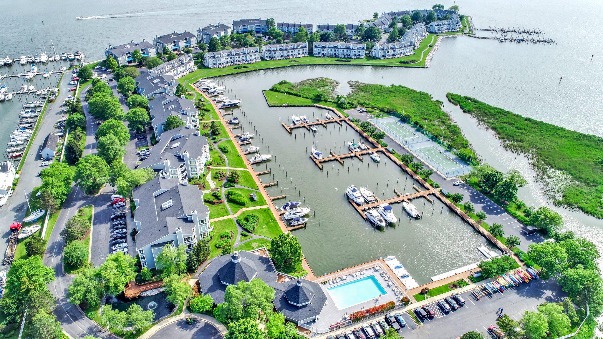Welcome to this sought-after WATERFRONT END townhouse with SPECTACULAR PANORAMIC VIEW! This southern exposure is ideal for watching the boats head toward St. Michaels, Oxford & Annapolis.  Oyster Cove  is a gated community and is a perfect place for your home office.  Nothing soothes the soul  like looking at gorgeous, blue water.  Enjoy the outdoors from any of your 3 decks - front, rear & primary suite.  OPEN FLOOR PLAN with fresh paint throughout.  First floor offers hardwood floors and full bath! !   Kitchen has Corian counters, window seat, backsplash, ss appliances, convection oven, side-by-side refrigerator with freezer drawer at bottom and TV to enjoy while preparing your favorite dishes for your family and friends.  LR has gas FP and spacious deck with retractable awning and gate.  Bonus room on first floor - entertainment center with large TV could be used for an  office/den/bedroom.   2nd floor has LVP flooring, laundry room, guest bath and a primary suite offering waterfront deck,  large W-I closet, jacuzzi, W-I shower & spacious vanity.  Second and third bedrooms have water view & wonderful light. Third floor loft has a great water view,  carpet and may serve as a  2nd primary suite with bath for guests/den/office.  Wonderful storage space.  4 FULL BATHS!   Furniture on both decks included if desired . Beautiful clubhouse has new furniture, gym w/TV, kitchen for socials & rental occasions.  Monthly get togethers & holiday parties are an opportunity to meet your neighbors.  Take in the morning sun on the 1.5 mile waterside walking path.  Also there are 2 marinas (1 in protected, deep water) with 100+   35'-60' slips available to rent/buy.  Take a dip in the salt-water pool, rent 1 of the 6 jet ski docks or play a game of tennis/pickleball.  Storage is available  for > 100 kayaks.  Walk to 5 restaurants!  Near 38-mile Cross Island Trail - great for biking, jogging, dog walking, etc.  Pet-friendly community - check with HOA on breed restrictions.   Change your address & change your LIFESTYLE!
