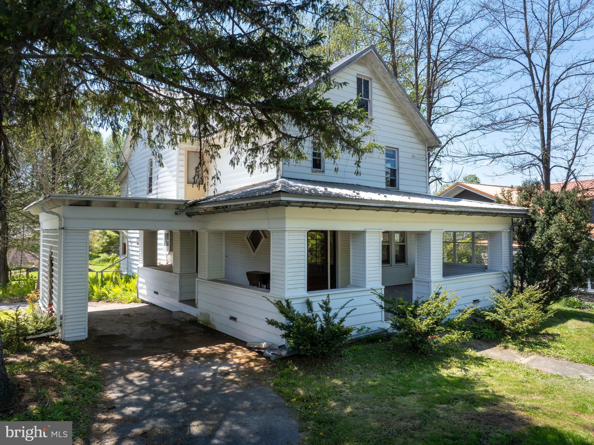 Looking for a 3-bed home in Millheim with historic character, flexible space, and a Main Street location? This 1920 home at 147 E Main Street blends classic charm with practical updates, including mostly updated windows, a newer metal roof, inviting outdoor areas, and lower-level potential for work, storage, hobbies, or creative use. Set on a 0.28-acre lot with mature trees, this home welcomes you with a grand covered porch, classic white exterior, and timeless curb appeal. Inside, you’ll find warm hardwood floors, ceramic tile, chestnut wood trim, wide room openings, original-style doors, a detailed staircase, and large windows that bring natural light into the main living spaces. The open floor plan creates comfortable flow through the home, while the kitchen offers a cheerful breakfast nook, checkerboard flooring, stainless appliance, double sink, and practical workspace. This 3-bed home in Millheim also includes 2.5 baths, an attic with generous storage, and a lower level with flexible possibilities for storage, hobbies, workspace, or in-home business use, subject to local requirements. Outside, enjoy the shade of mature trees, the covered porch, side covered parking area, and a detached garage that may also serve as a workshop. Photo-visible character details include the glass entry door with sidelights, diamond accent window, wood staircase, substantial trim, and spacious rooms with classic 1920 appeal. 147 E Main Street offers character, function, storage, and opportunity in one memorable Millheim property. Schedule your showing to see the porch, floor plan, garage, lower level, and charm in person. 
*Various home scenes were virtually staged or created.*