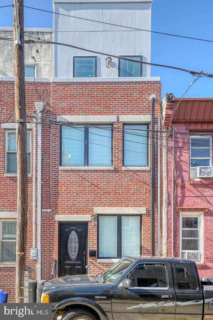 Tucked away on a low traffic block just off Washington Ave in Passyunk Square, you'll find 1211 Peters St. This newer (2022) 3-story home offers 3 beds, 2 baths, a roof deck, and a tax abatement. The front of the home greets you with a classic red brick facade. Inside, a pair of tall windows fill the living room with natural light, while dark hardwood floors provide warmth. A closet at the center of this level holds the gas furnace and electric water heater. At the rear, the stunning all-white kitchen is fitted with shaker cabinets, stainless steel Frigidaire Gallery appliances, quartz counters, and a subway tile backsplash. There's plenty of room here for a table or a cart with seating. Out back, a privacy fence encloses the patio and central A/C unit. On the home's second level, there are bright bedrooms on opposite ends, each with organized closets, flanking a bathroom at the center. The third level of the home is dedicated to the primary suite with a spacious bedroom and a spa-like bathroom adorned with a double vanity and a smart LED mirror. Topping off this fantastic home is an expansive roof deck with tons of space to spread out and entertain on good weather days. In addition to everything inside, 1211 Peters St's spectacular location, by the border of Passyunk Square, Hawthorne, and Bella Vista, earns a Walk Score of 94! It's just a few blocks from friendly local shops, Target, Sprouts Farmers Market, and Wine & Spirits. The top-rated restaurants that line E. Passyunk Ave, the iconic 9th St Italian Market, and playful Capitolo Park are all nearby. Plus, there's easy access to public transit, Washington Ave and Broad St. Schedule your in-person today!! Photos are from previous listing. Currently rented for $2570 mo, lease ends 5/31/26.