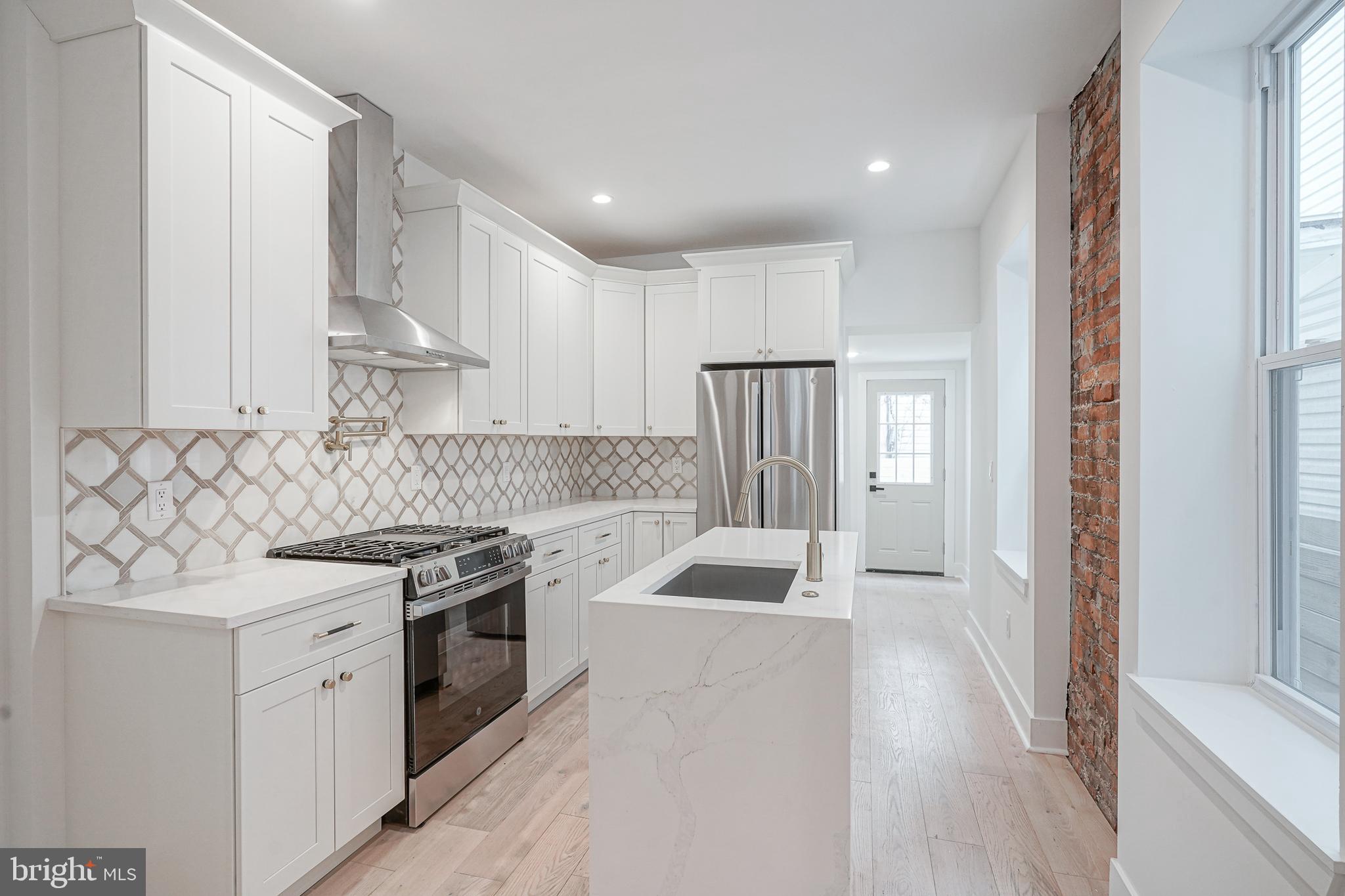 Step into this stunningly renovated home where modern design meets timeless character. Boasting 3 generously sized bedrooms,1 full bathroom, and 1 half bathroom is a one of a kind. Bathed in natural light, the sunroom is ideal for a cozy reading nook, a plant lover’s haven, or an inviting lounge area. The open-concept layout flows effortlessly into the bright living room. This spacious living room features original exposed brick accents, real hardwood floors throughout, and custom shelving perfect for decorating and storage. This room provides warmth, texture, and charm. Heading into the kitchen is the heart of the home. This beautifully designed kitchen, outfitted with sleek stainless steel appliances, high end marble, custom cabinetry, and a striking waterfall island doubles as both a functional and stylish focal point. Behind this kitchen is a half bathroom and coffee bar station. The backyard features spacious private outdoor space perfect for entertaining. Heading upstairs is 3 generously sized bedrooms and 1 full bathroom. The primary bedroom boasts ample closet space and south facing sunlight. The fully finished basement features high ceilings, additional living space, and the washer and dryer room. Walking distance to restaurants, coffee shops, and transportation you do not want to miss the opportunity to tour this beautiful home.