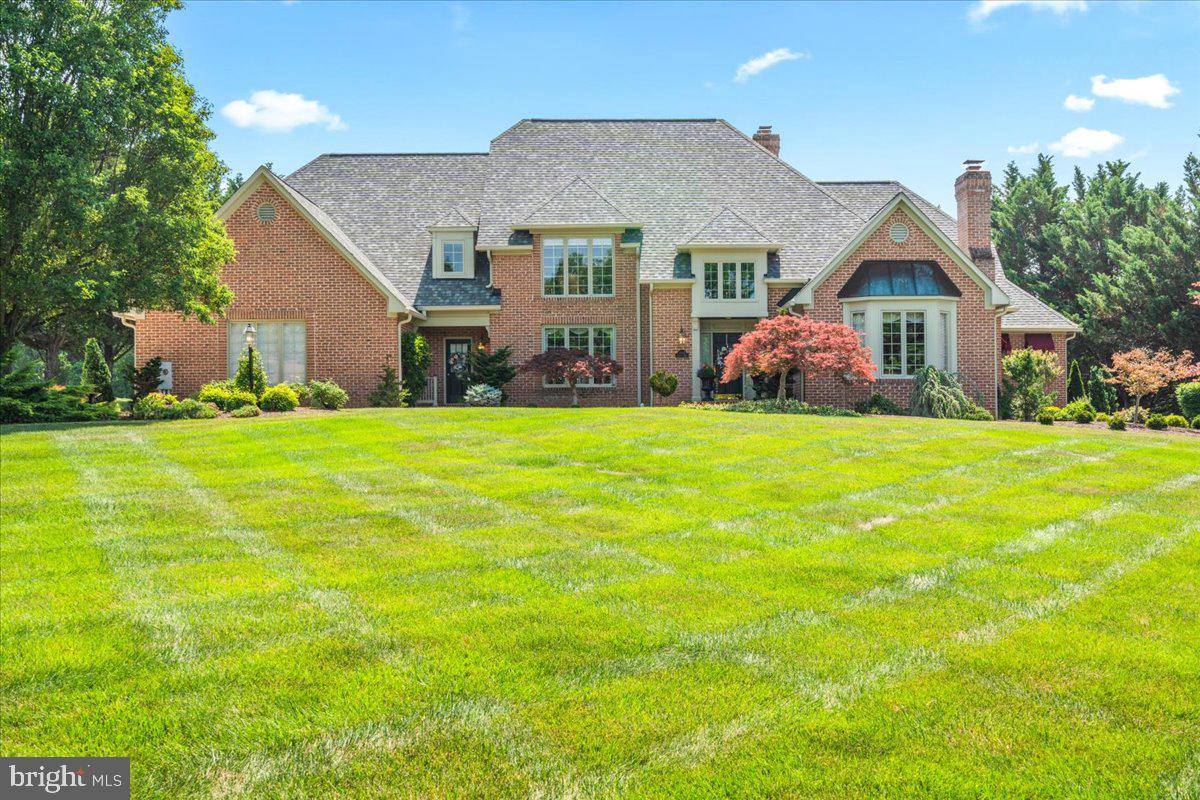 Stately elegance meets modern luxury in this meticulously maintained, custom residence built by Colonial Distinctions. Nestled on a beautifully manicured 1.24-acre lot in the coveted community of Redamar Estates, no detail has been spared in this architectural masterpiece. The grand two-story foyer welcomes you inside, leading to a dramatic family room anchored by a soaring, floor-to-ceiling brick fireplace, skylights, and custom built-in bookcases. Designed for the culinary enthusiast, the gourmet kitchen boasts premium upgraded countertops, custom cabinetry, a breakfast bar, and a gas cooktop. Enjoy casual meals in the sunlit breakfast room, or step outside to the expansive brick patio for seamless al fresco dining. Hosting is effortless in the formal dining room, rich with elegant wainscoting and triple crown molding, while the sprawling 25x12 sunroom offers a light-flooded sanctuary perfect for relaxation. Upstairs, the second level features four generously sized bedrooms and two full baths. The impressive lower level serves as an ultimate entertainment hub, boasting a dedicated billiard room with a classic Tiffany lamp, a second family room with its own cozy brick fireplace, a private exercise room, and a full bathroom. Premium conveniences abound, including custom built-ins throughout, a main-level laundry room, central vacuum, and a high-end architectural shingle roof (only 3 years old). Enjoy pristine, lush privacy in the treelined  backyard.  Just minutes from Frederick and convenient to I-70.