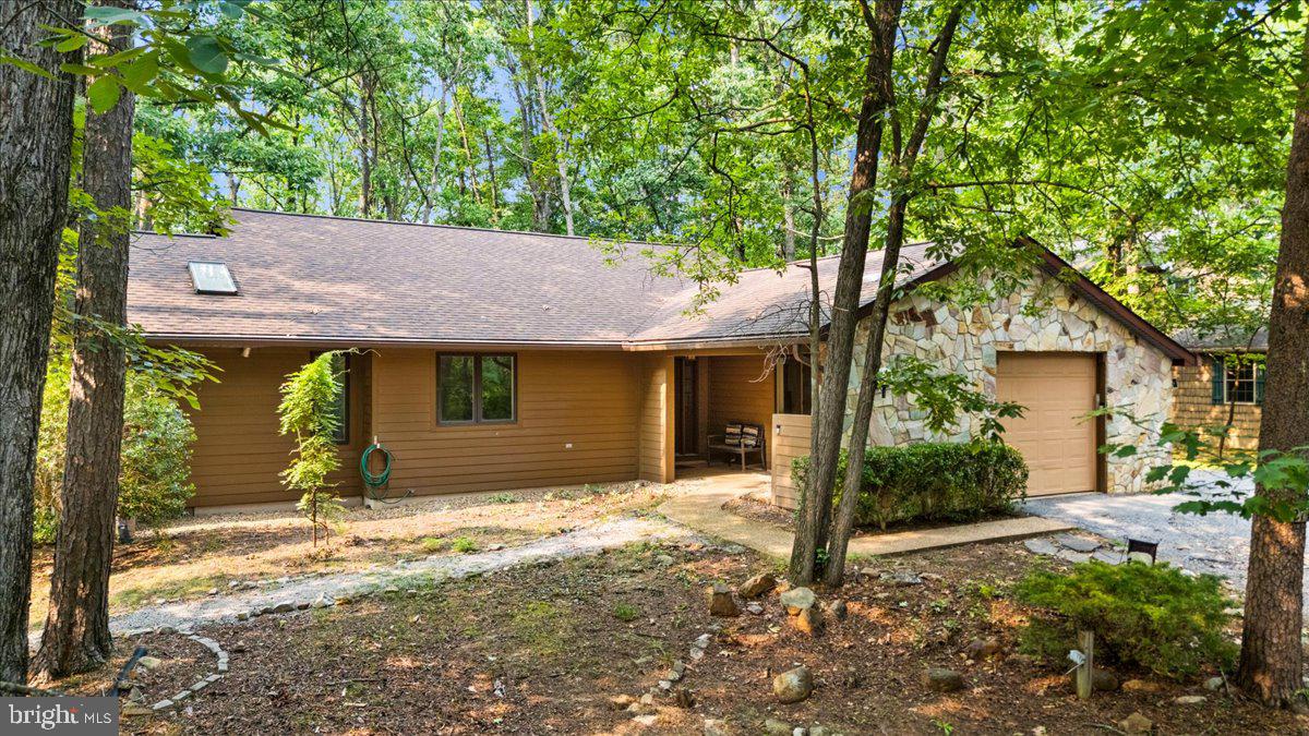 Renovated single-level contemporary set in the woods, vaulted ceilings in main level living area with skylights and gas fireplace, four-season sun room spanning the entire width of the house overlooking the woods onto large, multi-level deck with hot tub. Property interior was completely renovated in 2018, with new kitchen featuring granite counters and stainless steel appliances, new baths, new roof and decks (2019), New LP Smart siding (2021), new flooring in hall full bath (2026), new vinyl plank flooring in sun room (2026), fresh interior paint throughout (2026). Turnkey rental with established rental history being sold completely furnished. Located in the Massanutten community, a four-season resort with skiing, golf, hiking, mountain biking, indoor/outdoor water park, dining and many other amenities.