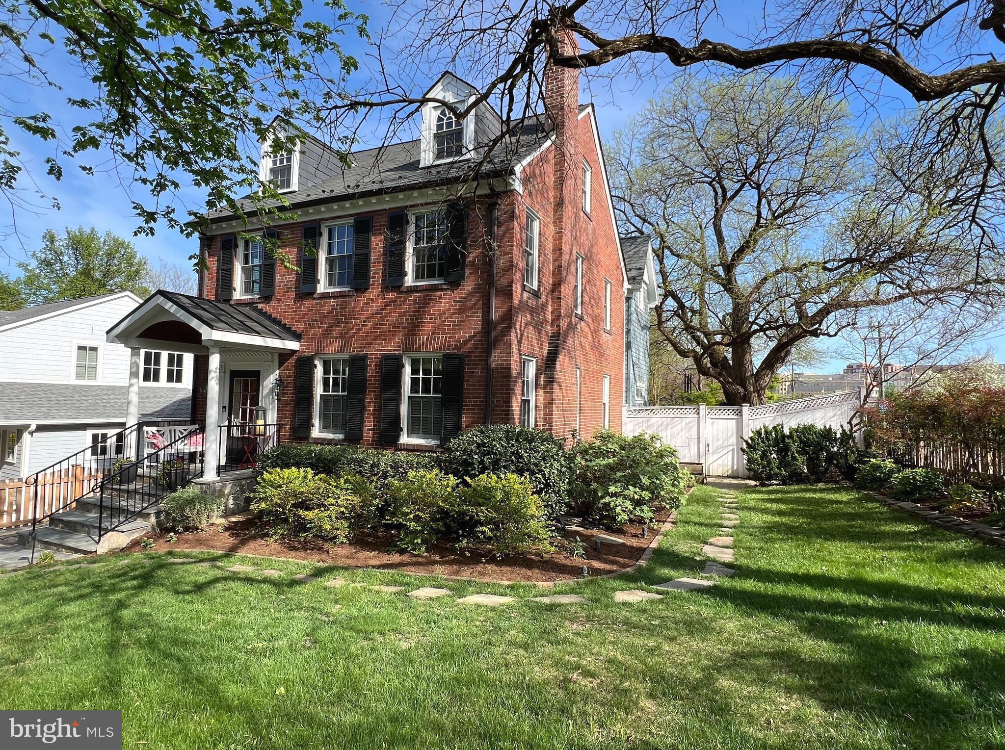 Immerse yourself in the charm of this beautifully renovated and expanded home by "Constructive," blending traditional elegance with contemporary flair. Nestled in the shadow of the Masonic Temple, this urban oasis offers over 3,000 sq ft of living space surrounded by mature trees and perennial gardens. The covered portico welcomes you to a home full of character and functionality. The spacious living room with wood-burning fireplace and moldings is bathed in natural light, while the formal dining room is steps from a service area with custom cabinetry with wood counters, lighted glass cabinet and wine refrigerator. The expansive kitchen features white cabinetry, soapstone counters, and stainless appliances, perfect for culinary delights.  A large center island with soapstone counter and seating.  There is a hall powder room and pantry for additional storage. The family room is the perfect place for gathering and entertaining. The wood floors are heated and keep it toasty in the winter.  French doors leading to a magnificent back yard with tiered flagstone patios, perennial gardens and landscape lighting encourages al fresco dining, BBQs  morning coffee or a relaxing evening...this backyard is magical!  Upstairs there are 3  bedrooms, 2 full bathrooms and a bonus  finished third upper level ( perfect play room, bedroom or home office)! A tranquil primary suite with vaulted ceilings, luxury bath with double vanity, oversized shower and heated floors. There is a coffee bar w/cabinetry & fridge, walk in closet, and private balcony with panoramic views! Two additional bedrooms share a generous hall bath with tub.  The versatile lower level recreation room with heated tile floors, built-ins, exposed brick walls... is the perfect spot for a comfy couch to binge watch movies! Don't miss the back bedroom/bonus room with full hall bathroom, perfect for a guest room or au-pair room.  The home has many SMART features to  include thermostats, smoke detectors, 17 SMART light switches, motion sensors and kitchen blinds. Double gates on the side open to parking area and brick storage cottage! Low voltage exterior landscape lighting &  security lighting. 200 amp electric panel & buried exterior cable. Water & Sewer lines have been replaced.  Park the car in the drive and enjoy the walkability to METRO, shops, restaurants, VRE, Old Town & Del Ray! This home truly checks all the boxes for urban living at its finest!