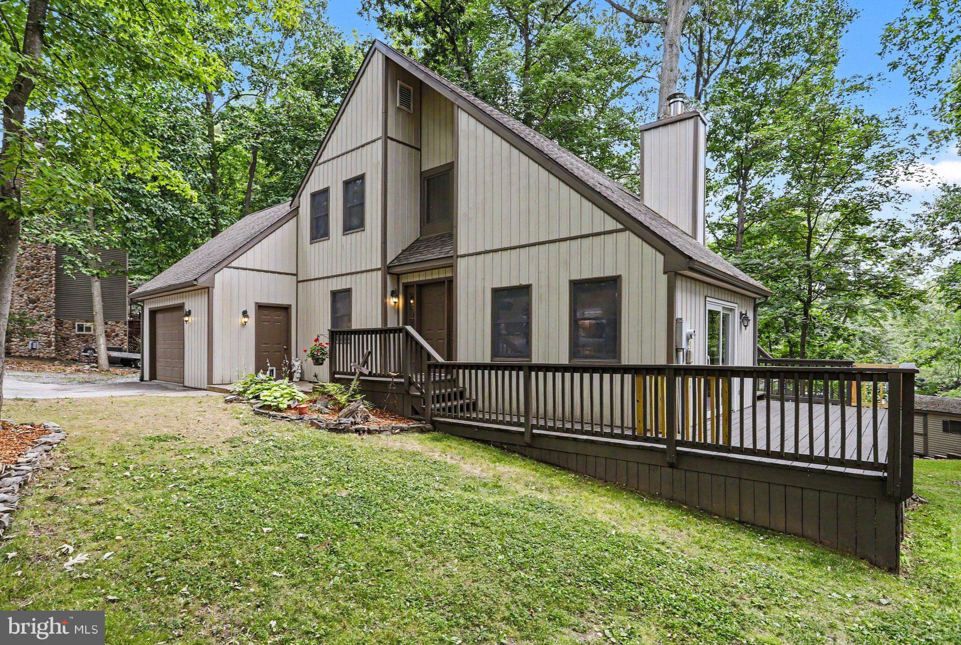 Tucked among mature trees in Fairfield, PA, this unique contemporary home offers a peaceful setting that feels like you're living in the treetops. The spacious wraparound deck is the perfect place to enjoy your morning coffee, unwind in the evening, or simply take in the surrounding nature. Inside, you'll find 3 bedrooms, 2 full baths, and luxury vinyl plank flooring throughout. The main level features one bedroom, one bath, laundry, kitchen, dining room and a living room that is the true centerpiece with its soaring two-story ceiling and striking stone backdrop for the gas fireplace.  Upstairs you'll find another full bath and two bedrooms- one with an attached bonus room that's ideal as a playroom, home office, hobby room, or workout space. Outside, the property has been thoughtfully designed with extensive hardscaping, natural stone flower beds, a welcoming front porch, a firepit for evenings under the stars, and a storage shed. An attached garage and a 30-amp RV hookup add even more convenience. Located just minutes from Liberty Mountain Ski Resort, historic Gettysburg, and the Maryland/Pennsylvania line, this home offers the perfect blend of privacy, character, and accessibility. If you've been looking for something a little different with plenty of charm, this is one you won't want to miss.