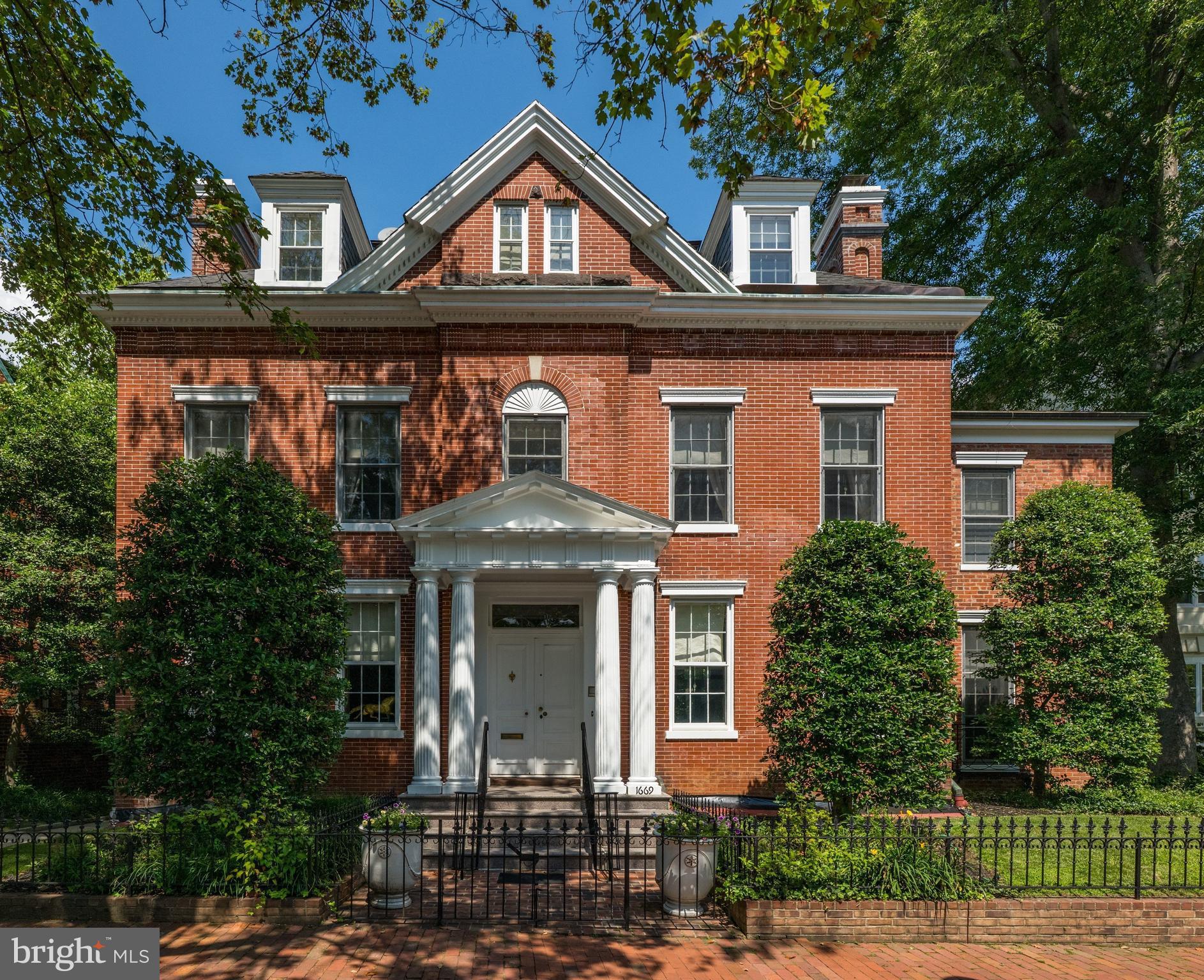 1669 31st Street NW is being offered for sale for the first time in almost 50 years and welcomes you with the warmth of elements of Jeffersonian Classical and Neo Classical architecture.  The red brick exterior with white columns spans four levels in its entirety.  Located directly across the street from the gardens of Tudor Place one will find views from the front rooms of the home are seasonally spectacular.  From the moment you enter this elegant high ceilinged residence one can just imagine the array of prominent owners that graced its halls. Sited on a beautiful parcel of land that was originally part of 6 acres, then sold  in 1802 by the second Mayor of Georgetown Thomas Beall (a direct descendant of George Washington) to the original owner, the residence has since been owned by several notable families and cabinet members.  Once inside the home,  the natural light and abundance of windows and french doors allow beautiful views from almost every room. The vestibule and grand foyer with wide staircase provide the centerpiece of the home, from which the expansive dining room (which seats 22) and formal double parlor living room balance each wing of the residence.  The double parlor living room with fireplace and bar area open to a large library/sitting room with built-ins and corner windows.  .  The wideplank floors and graceful mouldings are a testament to the historically preserved architecture.  The main hallway and dining room lead to a generously sized cooks kitchen with island and separate breakfast room, all graced with hand painted tiles.   A back staircase allows for a second stairway up to the second story of the home.   Off the main hallway one finds the coat closet, guest bathroom and  a set of french doors leading to the flagstone terrace, brick patio, expansive garden,  red brick poolhouse/guest house and landscaped gardens.   A one car red brick  garage completes this main level of the residence.

The second story of the home provides for a two room primary suite with pocket doors,  two fireplaces and a luxurious spacious primary bath.   A second guest bedroom across the hall with fireplace, large bath and built in wardrobes mirror the shape and size of  the primary sitting room.   Two additional bedrooms and two additional baths complete this level of the home, and offer a small balcony off the hallway.   Continuing to the third story of the home one will find extra large bedrooms number 5 and 6 each with an ensuite bath, walk in closets, multiple dormer windows and flooded with light.

The lower level of the home accessed from the kitchen staircase includes a spacious bedroom  (bedroom 7), a full bath, a sitting room, full laundry, half-bath, wine cellar, storage rooms and utility room.   A side entrance leads to both a private walkway and gated entrance to the garden.

In approximately 1983 and in 1991, the current owner renovated the home to add the swimming pool,  pool house/guest house, brick patio and also renovated the kitchen and all bathrooms.  A grand home with all the right spaces for entertaining and family living, awaiting a new owners special touches to make it their own.   An outstanding floorplan with an abundance of light, high ceilings on all three main and upper floors make this home truly special.   By appointment with 24-48 hour notice.  Registration form required.