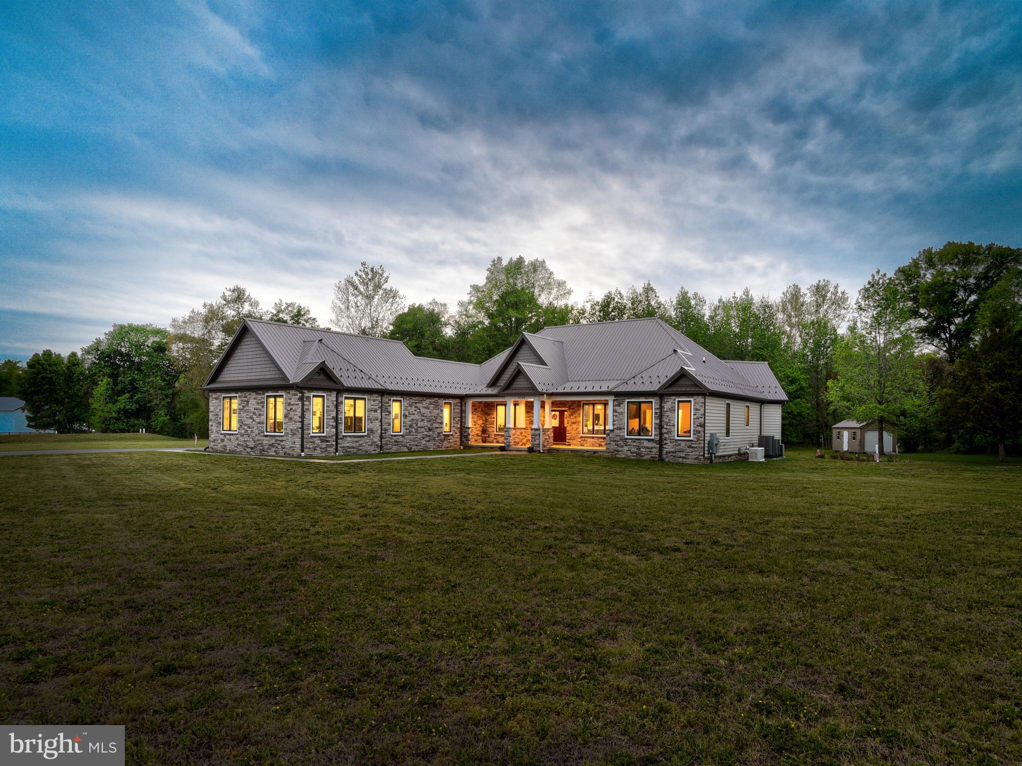 Set on just over 11 private acres in Port Tobacco, Maryland, this custom-built rambler offers the ease of single-level living paired with thoughtful design and quality craftsmanship and luxuries throughout. Built just six years ago and topped with a 50-year metal roof, the home is designed for both comfort and longevity. 

Inside, the open-concept layout seamlessly connects the foyer, living, dining, and kitchen areas, creating a bright and welcoming central space. The living room features a gas fireplace with mantle and opens to a rear porch and patio, an easy and welcomed extension for outdoor living.  

The kitchen is well-appointed with custom cabinetry, granite countertops, stainless steel appliances including a gas range and oven, dual wall ovens with air fry, convection, and microwave capabilities, dishwasher and a French door refrigerator with a built-in Keurig brewing system. 

A standout feature of the home is its three primary bedroom suites, each offering privacy and flexibility. The first overlooks the front grounds with a full bath. The second and third suites enjoy views of the rear property and direct access to the rear porch and patio. One includes a separate soaking tub and walk-in shower, while the other is more spa-like in design, with dual vanities, a freestanding soaking tub, an oversized custom shower with body jets, and an expansive walk-in closet and dressing area. 

Additional spaces include a laundry room, half bath, and mudroom just off the garage entry. The home offers 40" wide hallways, 36"+ doorways and door lever handles.  The home is equipped with Pella crank-out casement windows, remote shades, and a conditioned three-car side-load garage. Even the crawl space is climate-controlled, reflecting the attention to detail throughout. 

For added peace of mind, a 22kW Generac standby generator is in place for any power emergencies, along with an invisible pet fence surrounding the home. 

The property also features a substantial 60’ x 60’ metal outbuilding with power and two 12’ x 14’ front doors, as well as a separate 12’ x 20’ storage shed. 

Conveniently located near the Port Tobacco Marina and the many amenities of the surrounding area, this property offers a rare combination of prime location, space, privacy, and modern comfort.