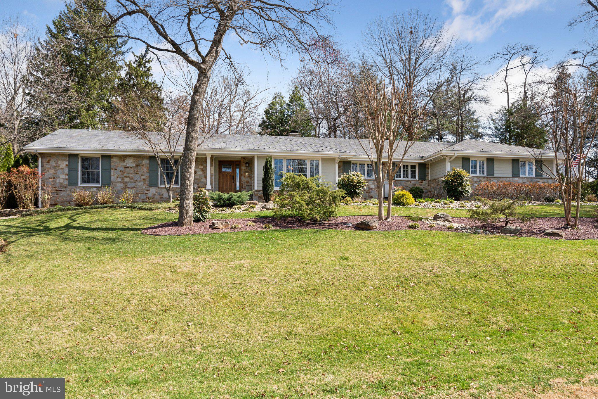 Experience the convenience of single level living in this exquisitely renovated custom stone ranch situated on a spacious corner lot! With significant investments in premium upgrades, this home showcases a Dura Slate roof, three beautiful stone gas fireplaces, two spacious slate patios, and high-end appliances. Step outside to discover a serene pond with a waterfall, breathtaking landscaping, and a spa perfectly integrated into Trex decking. Inside, you'll find custom millwork, hardwood flooring, and a generous walk-in closet. Additional highlights include a standby generator, dual-zone HVAC, a central vacuum system, and more. Plus, a versatile outbuilding/studio with its own HVAC and private patio enhances the functionality of this remarkable property. Don't miss out on this opportunity!