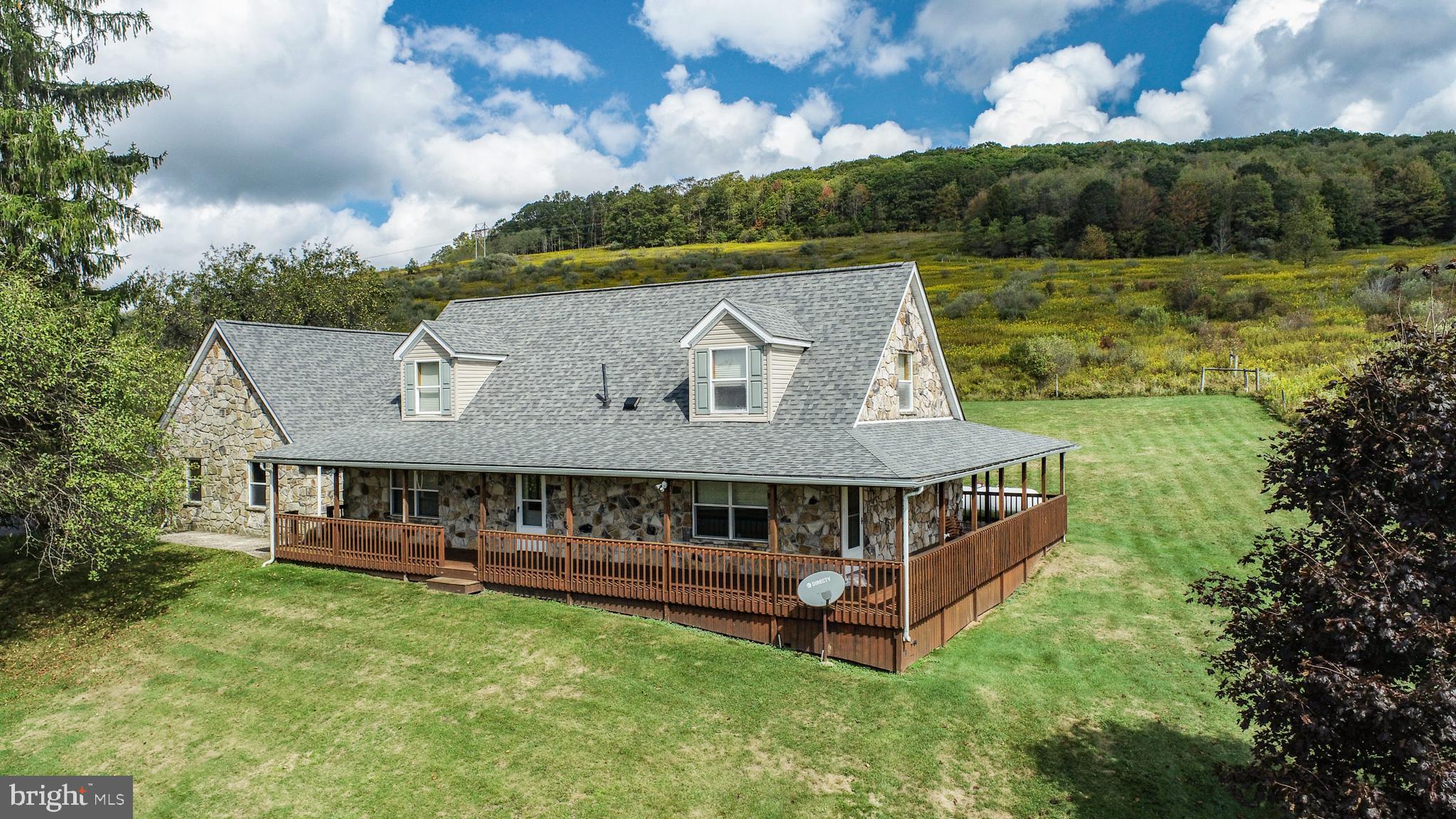 Surrounded by 100+ Acres of Nature Conservancy conservation lands,  on a 1.68-acre scenic home site, this 3-bedroom, 2.5-bath home combines natural charm with modern comfort. The native stone exterior and peaceful setting set the tone for this inviting residence. The wrap around deck is perfect for quiet time with beautiful views.  Inside, the main level features a spacious primary bedroom suite, heated breezeway/mudroom and attached garage.  Large Country kitchen & combined Dining area. The upper level offers 2 good size BR's, full bath and a den or family room. The full unfinished basement is heated and ready for additional living area. Roof system has been recently replaced and the heating is efficient propane Hot Water Baseboard. Separate Native  Stone covered Detached garage. Call for your private tour.   Estate Sale "Sold As Is"
