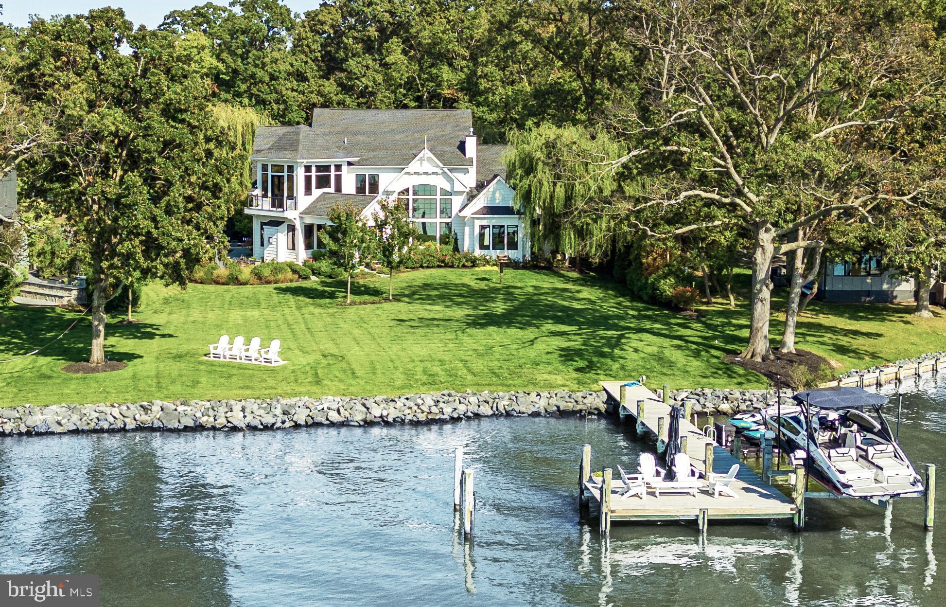 Silver Water is a rare west-facing waterfront home designed in direct response to the Chesapeake—offering broad water views, remarkable sunsets, and a level of architectural clarity seldom found in the area. Set behind a private gate on a beautifully landscaped one-acre lot along the West River, the property combines seclusion with convenient access to Annapolis and Washington, DC.

Spanning over 4,600 square feet, the home blends classic Chesapeake architecture with modern scale, light, and livability. High ceilings, oversized doors, and expansive windows draw the water into nearly every room, creating a constant connection to the horizon. The layout balances open, light-filled gathering spaces with a thoughtful separation of private areas, making it equally suited for everyday living and hosting guests.

The main-level primary suite is positioned to capture water views, with a fireplace, spa-like bath, and custom walk-in closet. At the center of the home, the kitchen is designed for both daily use and entertaining, anchored by professional-grade appliances and clean, functional design.

Outdoor living is fully realized. A waterside saltwater pool, bluestone terraces, teak decking, and a fully equipped pool house create a seamless extension of the home—designed for both relaxed days and larger gatherings. The lawn stretches to a protected shoreline, reinforcing the home’s connection to the water.

A private 70-foot pier with lift provides immediate access to the Chesapeake, ideal for day boating and spontaneous time on the water, with nearby marinas accommodating larger vessels.

Additional features include mature landscaping, a smart irrigation system, multiple outdoor living areas, a detached three-car garage, and a separate storage structure.

Silver Water offers a rare combination of design, setting, and livability—an intentional waterfront home where architecture and landscape come fully into alignment.