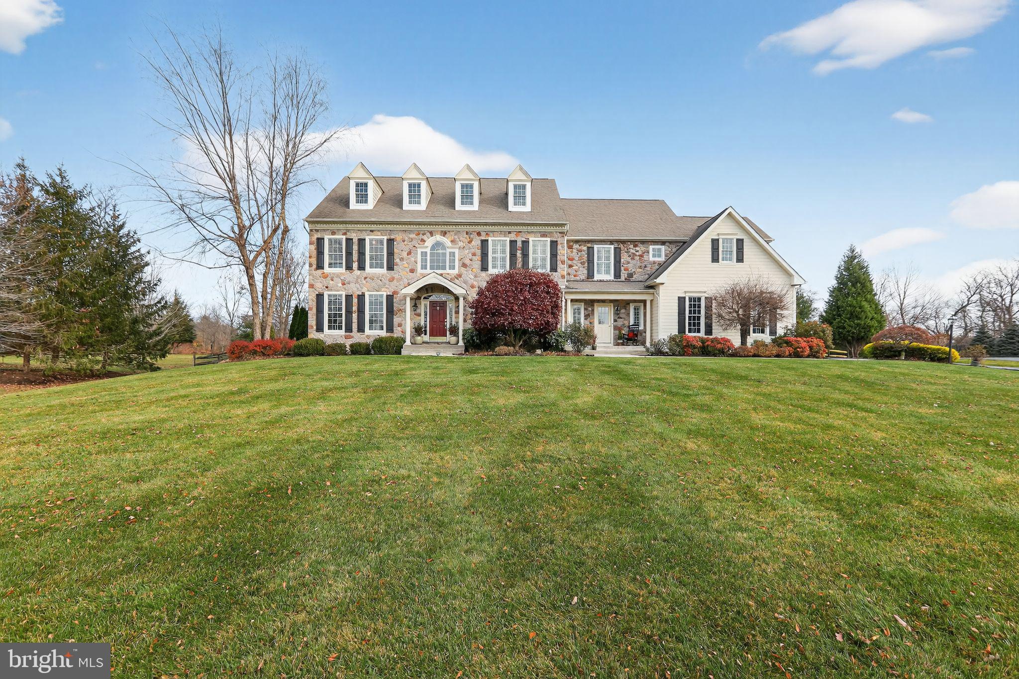 You don’t want to miss this stunning country manor style home nestled on a premium acre bordered by the natural beauty of Evansburg State Park. This lovely home is a perfect blend of comfort and quiet elegance which has been impeccably maintained and improved by original owners. As you approach, appreciate the classic farmhouse style, with both formal and casual covered entrances, and the secluded resort style backyard retreat! The primary entry welcomes you into a front to back reception foyer showcasing timeless architecture, charming details and French style doors leading to the rear patio. A traditional center hall, to the left is a fireside living room with gleaming hardwood flooring and beautiful custom millwork, both of which can be found throughout much of the home, and to the right a spacious dining room, with custom tray ceiling and wainscoting. Large windows usher in amazing natural light throughout the home. The handsome executive style office with park views invites working from home. Between the dining room and kitchen is an attractive and convenient butler’s pantry making hosting a pleasure. The kitchen, breakfast room and family room, with cathedral ceiling and stone fireplace, have an open flow making this the heart of the home where everyone will gather. The gourmet kitchen is a cook’s dream with extensive granite counters, beautiful cherry cabinetry and a large island with breakfast bar. There is a spacious built in work station to meet multiple needs: meal planning, family paperwork, homework, etc. The comfortable breakfast room offers access to the patio for easy grilling and outdoor dining. A favorite is the family room with a beautiful custom stone gas fireplace and Palladian window welcoming in views of the backyard and open space beyond. Enjoy gathering with friends and family for game and movie nights or cozy up with a good book in front of the fire. The Bowers and Wilkins audiophile surround sound in the family room brings the movie watching experience to life! The 2nd front entry is a more casual entry hall leading directly to the kitchen with interior access to the 3-car garage, powder room and back staircase. This space could easily be outfitted as a “drop zone” for today’s busy lifestyle. Take the beautiful turned staircase to the second floor arriving at the primary suite which features French doors and a double-sided marble surround gas fireplace. The sunny sitting room is the perfect place to enjoy your morning coffee. Continue into the primary bedroom with an impressive tray ceiling, custom millwork highlighting the fireplace, and double walk-in closets with organizers. The ensuite bathroom offers dual vanities, soaking tub, and updated shower. There are 3 additional, spacious bedrooms and 2 full baths, including a Jack-and-Jill, on the second floor. The 2nd floor was designed to accommodate a large laundry room with a sink, counter and built-in, making laundry day a pleasure! The finished, walk-up lower level features a large recreation room, kitchenette, flex room which could be a 5th bedroom, full bathroom and wine closet. Outside, the beautifully landscaped grounds and extensive hardscaping create a true retreat. A spectacular multi-level, salt water pool with vanishing edge and hot tub anchors the backyard, providing the perfect setting for relaxation and entertaining. The patio allows for multiple seating areas and features a built-in, propane fire-pit perfect for roasting marshmallows or warming up after an evening swim. The backyard is fully fenced with mature trees, landscape lighting and an irrigation system. Enclave at Evansburg is a small cul-de-sac community centrally located to Collegeville Boro, Historic Skippack Village, Providence Town Center, Corp Centers, Parks and Recreation areas. Served by highly regarded Perkiomen Valley School District. Don't miss the chance to make this beautiful property your new home!
