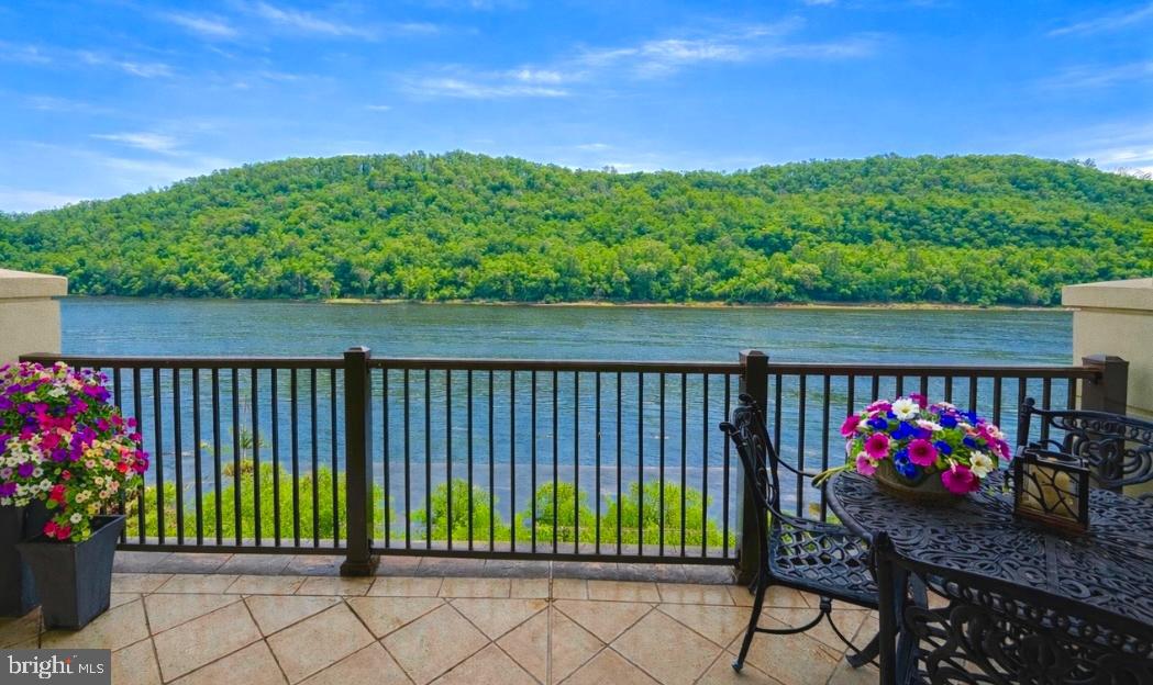 Experience the serene beauty and quiet whispers of the Delaware River from this exceptional second-floor condo nestled within prestigious Waterview Place. Suitable for the discerning resident, this residence is accessible via a private elevator that opens onto a tastefully designed foyer adorned by luxurious marble flooring. Once inside, your gaze is compelled by panoramic river views, enhanced by three en-suite bedrooms across an expansive 3,962 square feet of single-level living space. 510 Waterview Place is strategically planned to accommodate a high-end, low-maintenance lifestyle, conveniently located just minutes from downtown New Hope, PA.  The beautifully arranged living room features a stone fireplace and custom-built ins, leading directly onto a private, riverfront wrap-around terrace. The true charm of this condo lies in the understated elegance and restorative ambiance created by the ever-present proximity to the water. The lush hardwood flooring leads into a formal dining room situated just off the gourmet kitchen. Expertly crafted cabinetry by local artisan 'Superior Woodcraft' sets the tone while also highlighting a paneled Sub Zero refrigerator, Wolf double ovens, a Wolf induction cooktop, paneled Miele dishwasher and a bonus service/wine station equipped with an additional refrigerator, sink, and dishwasher. Perfect for grand gatherings or daily living, the kitchen's practical features are elevated by a beautiful window wall that reveals natural sunlight and sweeping views with every meal. An executive-grade office offers custom shelving for an extensive collection of books and memorabilia, a gas fireplace, and direct terrace access. The Owner's Suite presents captivating river views that enhance the suite's notable features: a dedicated private gym area, two spacious custom walk-in closets, and a bathroom boasting an impressive double wall vanity, jetted soaking tub, and glass walk-in shower. Completing this luxury condo are two additional bedrooms, both accentuated by modern bathrooms, and a powder room inspired by Japanese design.  As a resident of Waterview Place, you'll have access to private garage parking, ample guest parking, and impeccably maintained grounds— all essential elements of the elevated, turnkey lifestyle that the community is renowned for.  510 Waterview Place is a rare address defined by water, light & quiet elegance- all framed by the restorative rhythm of the river.