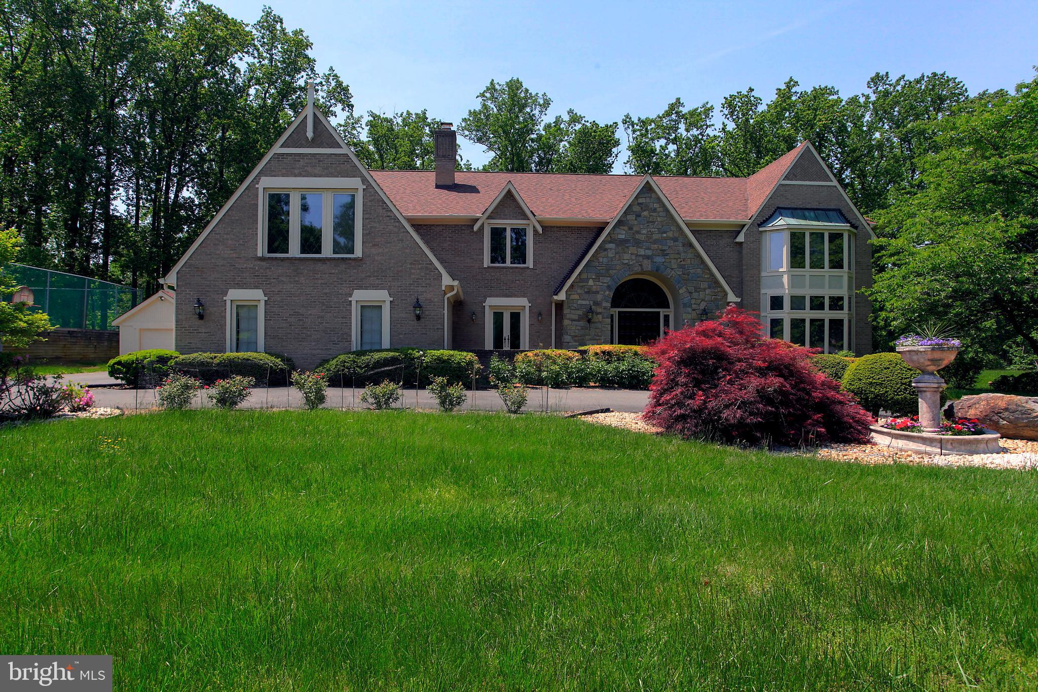 Welcome to a beautiful Potomac Estate on 2 lush acres located just past The Village on a quiet cul-de-sac.  Mature landscaping, brick construction, a tennis court with lights and viewing gazebo, patio, 3 car side entry garage plus a separate 4th garage make the exterior very special. The two story foyer is highlighted by a double door entry with arched glass window above and marble flooring. The generous living and dining room are easily accessible off the foyer. Overlooking the private backyard is a study and wonderful WFH space. The family room has a floor to ceiling stone fireplace with raised hearth and wet bar that makes the room warm and inviting, a perfect place for casual entertaining. The family room is open to the kitchen + large breakfast area with skylights and overlooks the backyard. The kitchen has wood cabinetry, newer appliances and granite countertops. The laundry room located close to the kitchen has a second powder room.  The balcony overlooks the foyer and family room.  The upper level has 4 generous bedrooms and 4 full baths. The Primary Suite  will please the most discerning buyers with its large bedroom + fireplace. The adjacent sitting room provides  a quiet place with built-ins to relax. The Primary Bath has two vanities, each with a sink, whirlpool tub, shower and 2 large organized walk-in closets. Spacious lower level  with a 58' long recreation room with wet bar, exercise area, guest room/den/office with full bath and two unfinished storage areas.