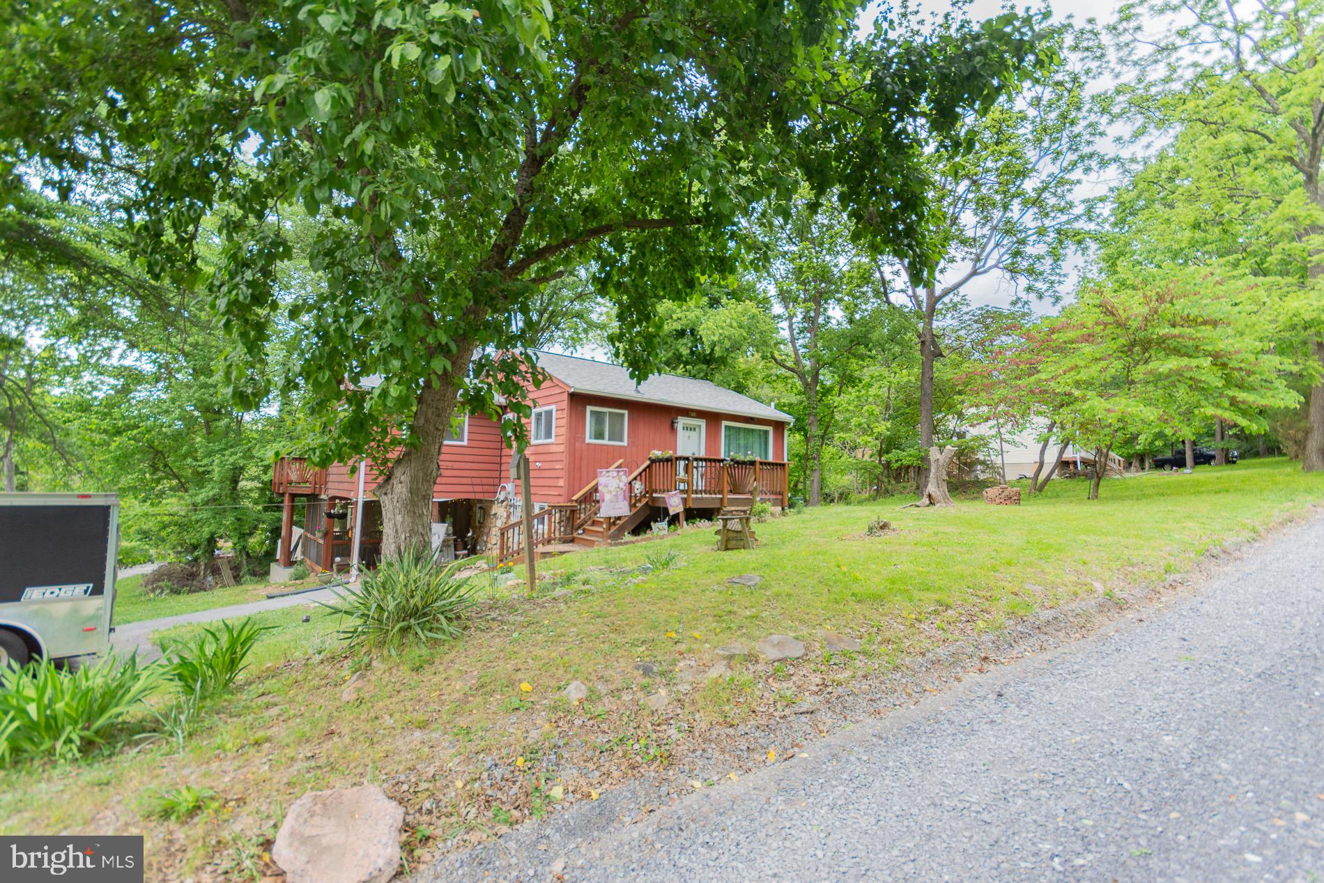 Welcome to this move in ready Chalet on over 3/4 acre corner lot with no HOA and access to a 55 acre lake within walking distance.  This home features 2 bedrooms 1.5 baths. A family room with electric fireplace and a country kitchen both with new luxury vinyl plank flooring. A laundry room with full bath and a screened in 27x17 porch that leads to a fenced area for pets or children to enjoy.  This completes the main floor. The upstairs has  a living room that goes out to your large deck .The sitting room has an electric fireplace. Two bedrooms and a half bath complete this level. The large corner lot allows you to entertain friends or swim in your salt water pool.  Newer roof, mini splits, water treatment system, dishwasher, refrigerator and flooring. This home offers to much to share. Come see for yourself ,make an appointment today.