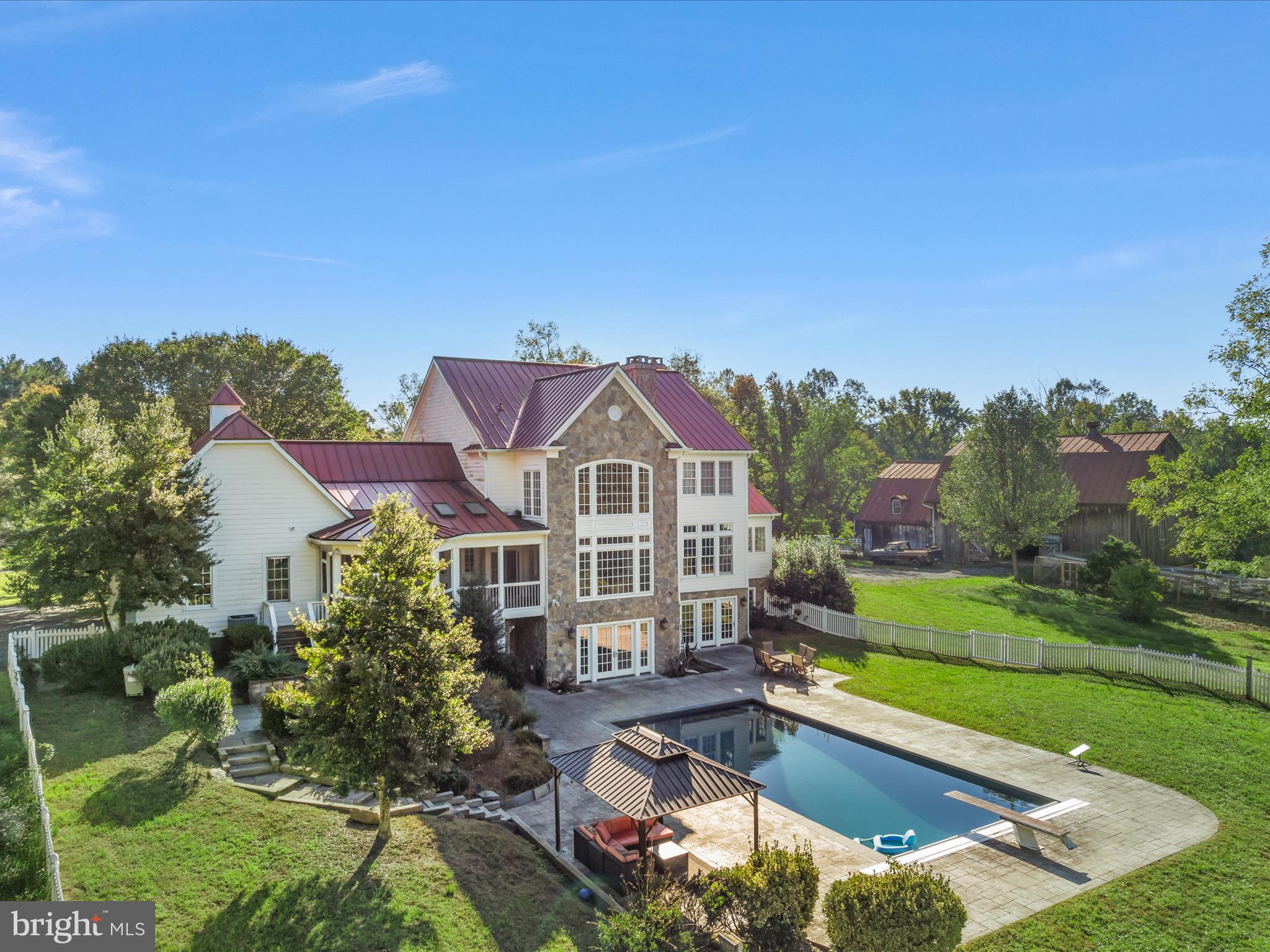 Springdale Farm – Premier 23.17 Acre Equestrian Estate with an exceptional blend of luxury living, equestrian facilities, and historical charm. Nestled in a tranquil setting, this property includes three beautiful homes (all with first floor primary bedrooms) & a phenomenal pre-Civil War barn with a lit riding ring.  Whether you're an equestrian enthusiast or simply seeking an idyllic country retreat, Springdale Farm presents a unique opportunity to own a piece of history & paradise.  ***The Main Home – The centerpiece of the estate is the primary residence, a magnificent Farmhouse built in 2003 offering 6 bedrooms, 5 full bathrooms, and 1 half bath (plus a rough-in for a full 6th bath). Thoughtfully designed with the utmost attention to detail, the home features: *Primary Bedroom on the Main Level*: The spacious primary suite provides a serene retreat, with an elegant en-suite bathroom, large separate office and walk-in closets.  *Gourmet Kitchen*: A chef's dream, the kitchen boasts high-end appliances, custom cabinetry, a large center island, built-in breakfast nook, and ample counter space, perfect for both daily living and entertaining.  *Elegant Living Spaces*: Enjoy an open floor plan that includes a formal dining room, perfect for hosting family and friends. The living room is bathed in natural light and features beautiful antique pine floors, & a stone fireplace that add warmth and character.   Stroll directly onto the *Covered Front Porch* from the dining room or primary bedroom.  Both have an entire wall of French doors that allow easy enjoyment of the front porch.  Enjoy quiet moments in the *Screened-In Back Porch* that overlooks the sprawling estate. The *Inground Pool* is perfect for those warm summer days, offering both privacy and tranquility.  ***Secondary Home – Also built in 2003, this fabulous Rambler offers 3 bedrooms and 3 full bathrooms, large kitchen & breathtaking living room with vaulted ceilings & fireplace.  The *Screened-In Porch* off the primary bedroom is an ideal spot to enjoy the fenced back yard in complete comfort. This home offers versatility and privacy while still being part of the estate.  ***Third Home –Step back in time with the *Pre-Civil War Guest House*, a charming updated  two-bedroom, two-bathroom home with 3 wood-burning fireplaces that exudes character and historical significance.   **Equestrian Facilities – Springdale Farms is also home to some of the finest equestrian facilities in the region. The *Pre-Civil War barn* still stands in exquisite condition, even though most barns were burned down in the Civil War - the owners claimed to be Northerners as the troops swept through burning down barns & the barn was spared!  This incredible barn was once home to President US Grant's Arabian stallion, Linden Tree & still holds an unmistakable feeling of prestige.  The barn has been meticulously maintained & restored, offering six stalls, each with automatic waterers, hot/cold wash stall, feed and tack rooms, a bathroom & laundry.  There are multiple pastures, all with 3-board vinyl fencing with automatic waterers.   There is a fabulous sand & bluestone riding ring with lights & round pen.  Whether you're looking to make this your dream home or an active horse farm, *Springdale Farm* offers everything you need for a luxurious and fulfilling equestrian lifestyle. With its history, prime location, superb facilities, and breathtaking homes, this estate is a rare find.