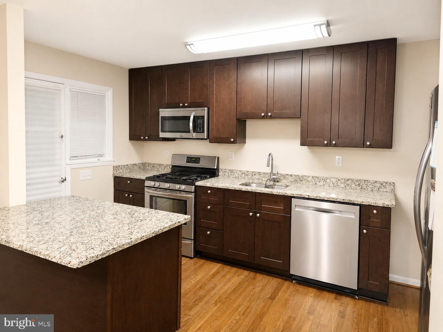 Welcome home to this beautifully maintained middle-group townhouse that showcases pride of ownership throughout. The updated kitchen features a center island, granite countertops, and ample cabinet space, making it perfect for everyday living and entertaining. Gorgeous hardwood floors add warmth and character to the main living areas. The updated bath offers a spacious ceramic-tiled shower stall for a luxurious touch.  The finished lower level offers exceptional additional living space and is currently utilized as a cozy library or reading room. This level also features a full bath, convenient laundry area, and ample flexibility for a home office, guest suite, or recreation space. Step outside to the deck overlooking the backyard, ideal for relaxing or hosting guests. Extremely well-kept and move-in ready Meticulously maintained and in excellent condition throughout.", this home combines comfort, style, and convenience.
