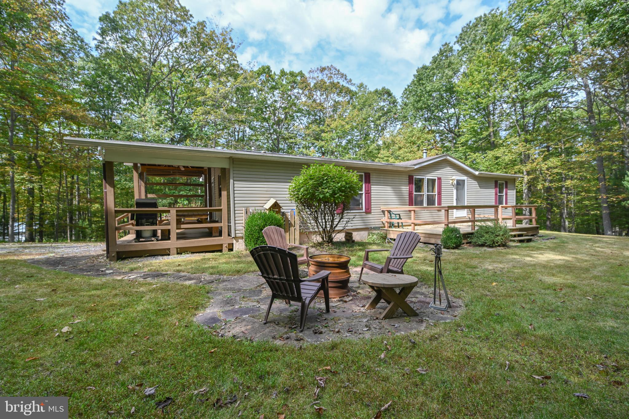 This private 3-bedroom, 2-bath cottage is tucked away on an oversized 1.24-acre lot at the end of a quiet street in the lake access neighborhood of Sky Valley. Inside the home offers a spacious open living area with a pellet stove for after skiing evenings. The kitchen is open to the living area and has ample cabinet space and room for a dining table.  The primary bedroom features it's own private bath with separate shower and soaking tub, while two additional bedrooms share a second full bath. A den/office adds flexible living space. The home also includes a full unfinished lower level with a separate outside entrance-perfect for storage or future expansion. The home offers affordable lake living with 3,000 feet of shared shoreline that rivals the Deep Creek Lake State Park. Three swimming platforms, roped off swimming area, picnic pavilions, docks with a jet ski area located in a no wake cove, and a stocked fishing pond—all part of a private community that feels like being in an upscale summer camp! Dock slip is through the association-When homes sell the slip goes back to the association. Until you get your assigned slip you can launch your boat at the Sky Valley boat launch. It is the only private neighborhood boat launch on DCL. Also explore the neighborhood on your golf cart or ATV! For the golfers in the group, it is only minutes to Thousand Acre Lakeside Golf Course. Surrounded by nature and set in a friendly neighborhood, this cottage is the perfect retreat for relaxation, recreation, and making memories at the lake!