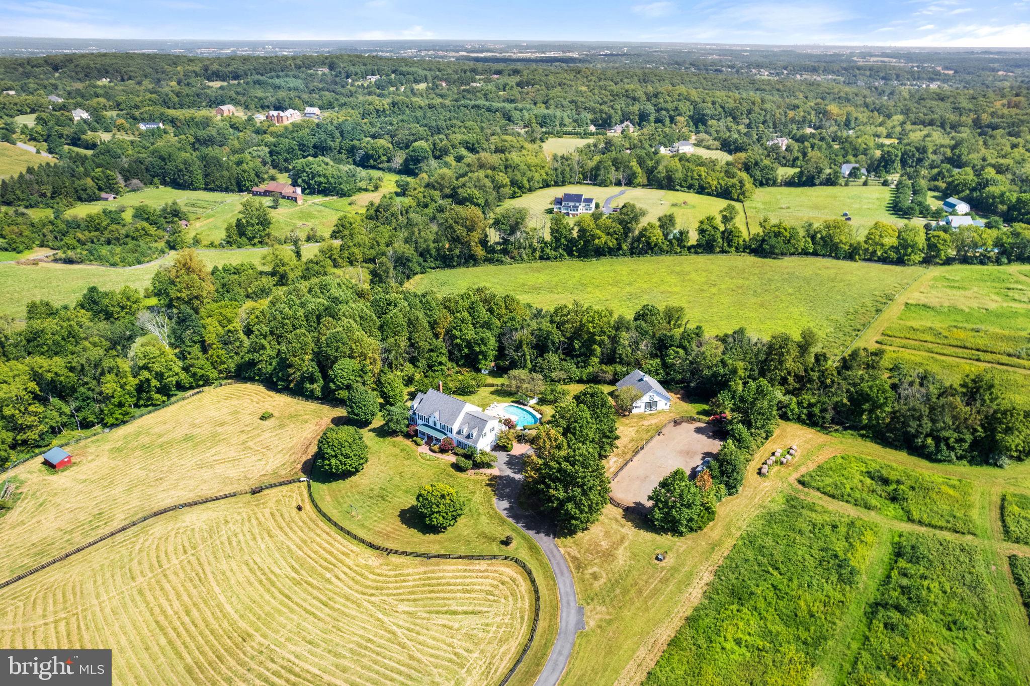This luxurious modern farmhouse encapsulates the perfect blend of elegance, comfort, and convenience, nestled in a prestigious hamlet of estate homes. Virginia living at its finest!
Ideal Location: Situated just minutes from the Dulles Greenway, with easy access on scenic paved roads, this property spans 28 secluded acres with breathtaking views. Bordering the tranquil Sycolin Creek and historic Woodburn properties, it offers an idyllic backdrop for your refined country lifestyle. Whether you dream of stabling horses, raising cattle, pampering llamas, or cultivating picturesque hayfields, this estate can transform your aspirations into reality.
Timeless allure and craftsmanship: Begin your journey in the inviting front foyer adorned with a custom-painted mural that sets the tone for the entire residence. The family room envelops you in comfort, while the chef's kitchen, designed for culinary excellence, is an enthusiast's dream come true. Savor your morning coffee in the sunroom adjacent to the kitchen & overlooking the pool & barn, before you retreat to either of the "corner offices" with picturesque views and high-speed FIOS connectivity.
Sumptuous Sanctuary: Upstairs, the primary bedroom suite offers a dreamlike oasis with a sun-filled picture window & updated en-suite amenities, including heated floors, a walk-in shower & a soaking tub with views of the tv screen above the door, a double-sided walk-in closet, & a laundry shoot. Three additional spacious bedrooms on the upper level, one with an en-suite bath and the others sharing a jack-and-jill double-vanity bath, all provide five-star views.
Entertainment Oasis: The walk-out lower level beckons with a spacious rec room featuring a mega movie screen, a second relaxed sitting area, & a full bath. Abundant storage and plenty of potential for additional finished space at pool level, make this area versatile and oh-so-fun! 
Modern Conveniences: Your comfort is paramount, with a generator, outdoor lighting, and security cameras ensuring peace of mind. The exterior boasts Hardieplank siding, updated double-hung windows throughout, large picture windows, and expansive 8-foot sliding doors to bring the outside in & maximize the views
Outdoor Paradise: Step into a world of outdoor enjoyment, where a saltwater pool beckons you to unwind. The property includes a 4-stall barn, a riding ring, board-fenced paddocks, scenic trails, and automatic waterers for your cherished animals.
Unlimited Possibilities: Whether you envision keeping horses at home, cultivating your own organic produce, raising chickens, or even nurturing bees in your backyard, here's your opportunity to enjoy it all. There's even plenty of room for expansion if you envision additional spaces. Its close proximity to downtown Leesburg (historic district, great restaurants, & shopping just 10 minutes away), the Dulles Greenway & Route 15 (10 minutes), national historic landmarks, over 50 wineries and breweries, and the Appalachian Trail (<20 minutes) keeps everything within easy reach.
Your Legacy Awaits: Presented by the original owners, this meticulously maintained & loved property on a private paved road offers seclusion and, simultaneously, an abundance of open space and potential for growth. More than a residence; it's a canvas for creating lifelong memories in a captivating and upscale Virginia setting. 
Please see the self-guided 3-D virtual tour for more photos. Enjoy its quality construction and design from day one or apply your vision — & welcome home!
