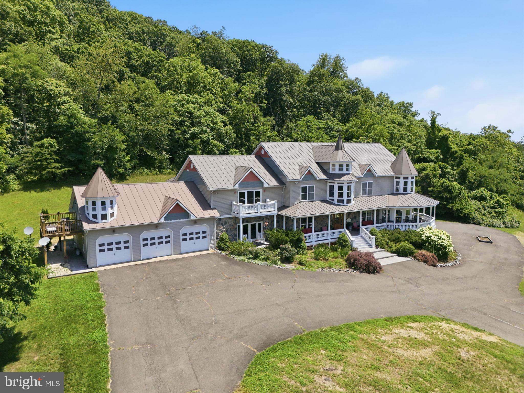 Perched atop 30 breathtaking acres in the heart of Rappahannock County, this extraordinary estate offers arguably some of the finest panoramic views in the region. From sweeping Blue Ridge Mountain vistas to rolling Piedmont countryside, every season provides a spectacular backdrop from the home's expansive wraparound porches and walls of windows.

Encompassing approximately 11,000 square feet, this custom manor-style residence offers six bedrooms, thirteen bathrooms, and two private apartment suites, creating exceptional flexibility for multi-generational living, guests, caretakers, or potential income opportunities.

The home's distinctive architecture features soaring roof lines, turreted towers, deep covered verandas, and generously proportioned living spaces designed for both everyday comfort and grand-scale entertaining. A spacious three-car attached garage provides ample storage for vehicles, recreational equipment, and hobbies.

The fully finished lower level is an entertainer's dream, offering a private recreation and hospitality space complete with a full wet bar, dedicated wine-tasting area with extensive wine storage, billiards room, comfortable lounge areas, and abundant space for hosting family gatherings, celebrations, or unforgettable evenings with guests.

Outside, the 30-acre setting provides exceptional privacy while remaining just minutes from the historic villages of Little Washington and Sperryville. Whether enjoying sunrise over the valleys below, entertaining on the wraparound porch, or relaxing beneath some of Virginia's darkest night skies, the property offers a lifestyle rarely found in today's market.

TLDR: 30 rolling acres zoned Agricultural.   13,211 square feet home (9,574 above grade, 3637 below grade) : 6 bedrooms, 10 full bathrooms, 4 half bathrooms, exceptional finished basement, 3 car garage, two separate apartments included in the bed / bath count. Past operations include B&B , Winery Tasting room and private residence.