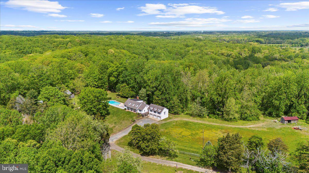 Rare offering: 40 expansive acres accompanied by a separate 5-acre  lot with passing 1997 perc test on file (county approval required;buyers to verify).Whether you envision a hobby farm, multi-generational retreat, or a private escape to roam freely, this property blends lifestyle, luxury, and potential.  Discover a rare 40+ acre retreat just minutes from downtown Annapolis, offering unmatched privacy, charm, and versatility. Tucked away on a quiet, no-through road, this property is a true sanctuary with rolling pastures, ATV trails, mature trees, and multiple outbuildings—including a barn and former horse corral.
This modern farmhouse has been thoughtfully upgraded renovations, including improvements to the roof, barn, electrical system, plumbing, fresh paint, new flooring, and updated bathrooms, making it move-in ready while preserving its storybook charm. Inside, six bedrooms and six bathrooms provide ample space. The main level features a welcoming kitchen with new quartz countertops flowing into a cozy family room with exposed beams and a fireplace. Entertain in the spacious dining room, or step into the sun-drenched office/parlor overlooking magnolia trees. The main floor also includes three bedrooms, highlighted by a luxurious primary suite with ensuite bath, private entrance, and panoramic pasture views. Upstairs, three additional bedrooms include one with a private bath and two connected by a charming secret passageway, with a nearby full renovated bath. 

The lower level offers a large recreation/tack room, workshop, additional half bathroom, and direct access to the three-car garage. Outside, tiered gardens, trails, and multiple activity areas—including a pool, golf practice area, and a secluded campsite with a fire pit—offer endless options for recreation and relaxation. The property invites outdoor adventure, with ATV trails, scenic hiking paths, and natural areas ideal for foraging and plant identification.

Conveniently located near golf courses, dining, shopping, and boating, this is more than a home—it’s a rare opportunity to enjoy a turnkey property with room to grow. Sale includes the 5-acre parcel known as 1118 Gumbottom Rd.(a previous perc was done in 1997).*Per the county, buyers must verify independently. Agents please see remarks.
