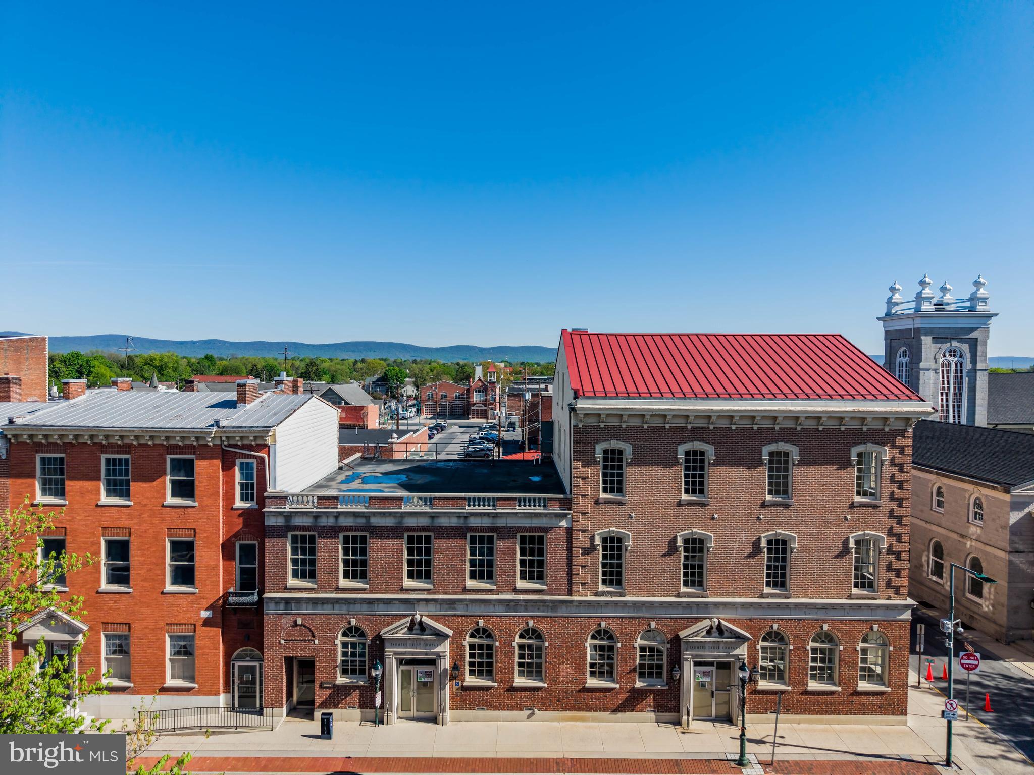 Positioned in the heart of Downtown Carlisle’s vibrant Central Business District and Historic District, this exceptional mixed-use property offers a rare opportunity to reimagine a landmark asset. Encompassing approximately 34,329 square feet on 0.61 acres, this former bank building consists of a striking two- and three-story masonry building originally constructed in 1863, rich with historic character and architectural presence.

Ideally located adjacent to the county courthouse complex and just steps from the town square, the property benefits from strong pedestrian traffic along West High Street—one of Carlisle’s most active corridors connecting the square to Dickinson College. The surrounding area is anchored by a dynamic mix of local retailers, institutional uses, restaurants, and businesses, creating an energetic and highly desirable downtown environment.

The building’s main level is currently configured with bank branch space and administrative offices, while the upper floors feature a combination of office suites and former apartment units ready for revitalization. Throughout the property, classic architectural elements shine, including beautiful masonry detailing, expansive arched windows that flood the interiors with natural light, and consistently high 10.5-foot ceilings that enhance the sense of space and openness.

Well-suited for a transformative redevelopment, the property offers significant upside potential. The ground floor lends itself to a variety of commercial uses such as retail, restaurant, or office space, while the upper levels present an ideal canvas for the creation of spacious, luxury apartment units—capitalizing on the building’s historic charm, ceiling heights, and oversized windows.

Additional features include a full basement with multiple interior and exterior access points, five roofing systems in adequate condition, various fire escapes, and 16 off-street parking spaces located at the rear of the property, easily accessible via side and rear alleyways.

This is a compelling opportunity to invest in and revitalize a prominent downtown asset in one of Central Pennsylvania’s most sought-after communities.