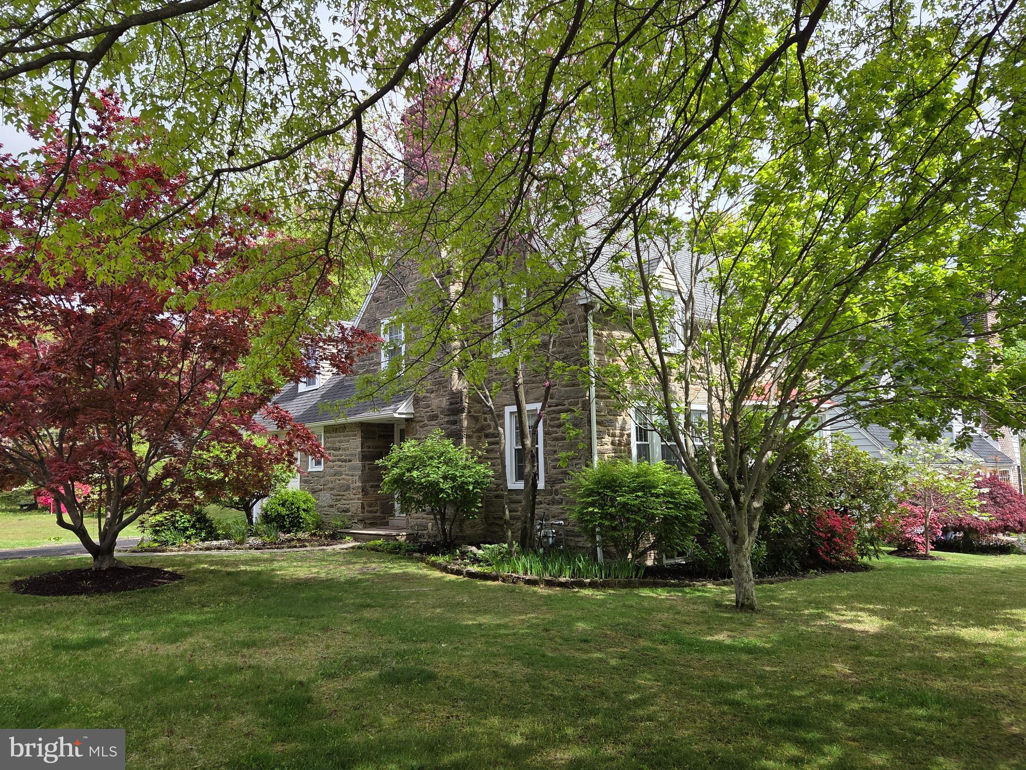 Beautifully maintained stone Colonial located in the desirable Highland Farms neighborhood, offering timeless charm, thoughtful updates, and an unbeatable location. Step inside to a spacious living room featuring gleaming hardwood floors, a classic wood-burning fireplace, oversized windows that fill the home with natural light, and elegant deep window sills. A convenient powder room and coat closet are tucked just off the foyer at the base of the staircase.
The bright and inviting dining room is ideal for everyday living and entertaining, complemented by charming wall sconces and abundant natural light. Beyond the dining room, the breakfast area features a pantry closet and flows seamlessly into the well-appointed kitchen, complete with plentiful white cabinetry, a gas range, dishwasher, and direct access to the backyard.   
Upstairs, the second level offers three generously sized bedrooms, each with ample closet space and attractive accent lighting. The third bedroom opens onto a private rooftop deck, providing the perfect spot to enjoy sunrise views. A full hall bathroom with a tub/shower combination, a linen closet, and access to the attic complete the upper level.
The full unfinished basement provides excellent storage space, workshop potential, laundry hookups, and a utility sink. Outside, lovely gardens and a sizable yard create a welcoming outdoor retreat. Conveniently located within walking distance to schools, shopping, and public transportation, this charming home combines character, comfort, and convenience—making it a wonderful place to call home.   Agent related to Seller.  Professional Photos available Wednesday night.