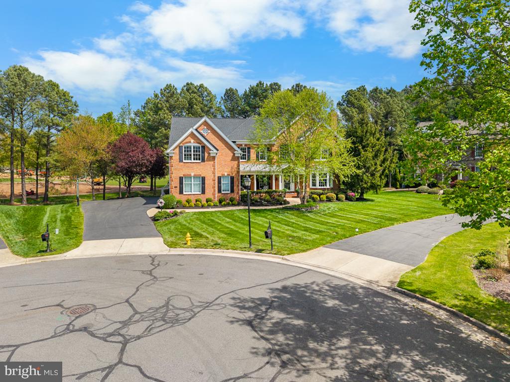 Contracts due by Sunday 5/25 at 5 PM**OPEN HOUSE 5/24 1-3PM*****There are many nice homes in Dominion Valley, but only a few Estate homes that deliver the full Country Club lifestyle. This stunning home sits steps from the Club, driving range, fitness center, resort-style pool, pickleball, tennis, Palmer's Grill, tot lot, and more — yet backs to the 8th hole of the legendary Arnold Palmer Golf Course inside this prestigious gated community. 

From the moment you arrive, you know this home is something special — landscape lighting illuminates the entire exterior. Gleaming hardwood floors flow throughout the entire main level. The formal living room wraps you in warmth with a brick gas fireplace and a bay window that flows seamlessly into the dining room, where a triple window bathes the room's extensive molding in natural light. The private office provides the perfect work-from-home sanctuary.

The heart of this home is a showstopper: a FULLY REDESIGNED GOURMET KITCHEN — just one year new — featuring a 6-burner gas range and oven, an electric wall oven, a microwave/convection oven, and a coffee bar, all wrapped in upscale, stylish finishes. The kitchen opens seamlessly into the soaring 2-story family room, anchored by a dramatic floor-to-ceiling stone fireplace with gas inserts and a wall of windows that frames the golf course like a living painting. In-ceiling speakers set the perfect ambiance for effortless entertaining.

Step through the glass doors into the custom 23-by-14-foot sunroom addition — surrounded on three sides by glass and overlooking the fairway — this is the space you will never want to leave. The full-length main-level deck extends your living even further, perfect for entertaining at any hour, in any season.

Upstairs, the owner's suite is unlike any other. A glass door leads to a private upper deck (over 300 sq feet) — your personal retreat for morning coffee or an evening glass of wine. Inside, a custom coffee bar with sink, microwave, and wine fridge sets the tone. The spa-worthy owner's bath delivers heated tile floors, dual vanities, a seamless glass shower with dual heads, and a jetted soaking tub.  Each upper-level bedroom has been updated and curated with intention. One enjoys the luxury of a private en-suite bath with Luxury Series Cambria countertops. The two additional bedrooms share an elegantly designed Jack-and-Jill bath — a true retreat of its own, featuring exotic granite, a shiplapped accent wall, and designer finishes that elevate every detail.

The lower level is a world unto itself. Gather in the theater room with a 100-inch projector screen and built-in banquet seating — perfect for cards, pizza nights, and movie marathons. A full wet bar with beverage fridge, a spacious recreation area, a private 5th guest suite with dressing area, walk-in closet, full bath, and laundry make this level as functional as it is fun. A bonus exercise/office room rounds out this exceptional space.

  Every detail has been considered — from the three-car side-turned garage and expansive driveway to the in-ground sprinkler system and holiday lighting package that keeps the grounds picture-perfect. A new roof, updated HVAC unit, and all-new kitchen appliances since 2023 give buyers the rare confidence of moving into a home where the work is already done. Simply arrive, settle in, and embrace the life you have been waiting for!