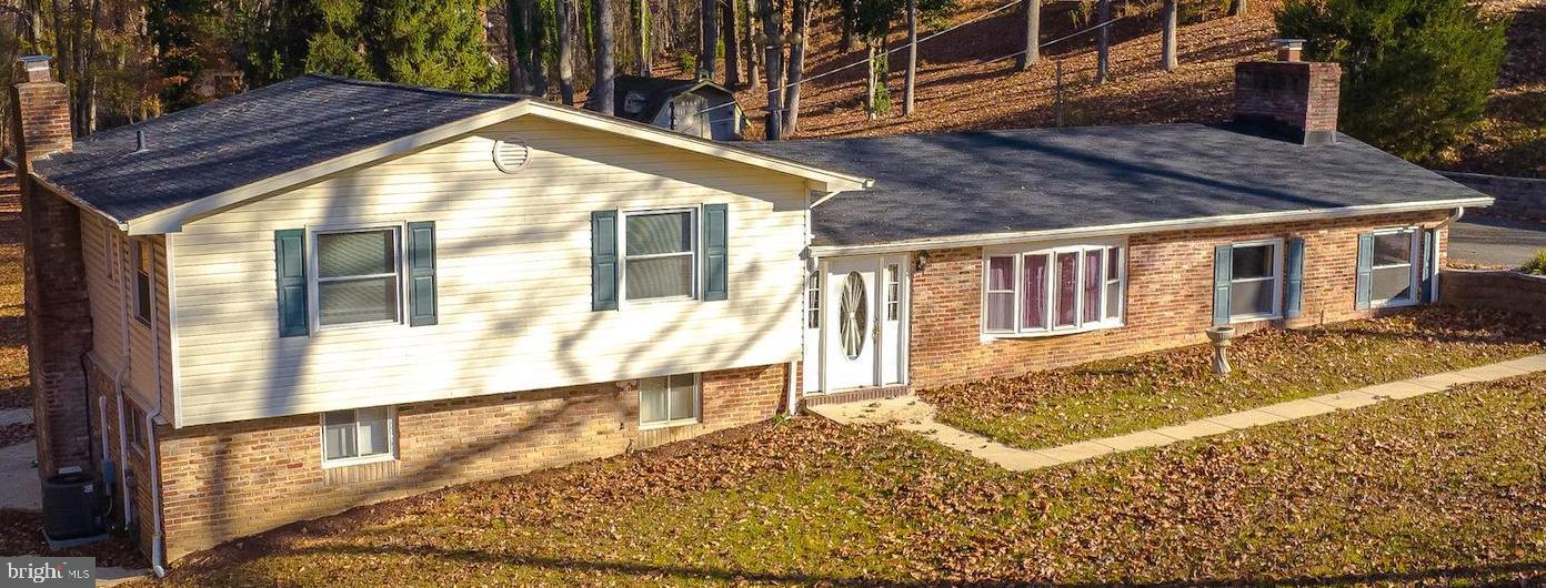 This meticulously maintained, custom-built home showcases Amish Mill trim and timeless craftsmanship. Fresh paint throughout, brand-new carpet, and a reconditioned crawlspace make this home move-in ready. The main level boasts an open floor plan with beautiful oak hardwood floors in the dining room and sunken living room. A floor-to-ceiling built-in bookcase and a charming brick fireplace with a brick tile hearth and wood storage nook add character and warmth. The spacious eat-in kitchen features a large side peninsula, a generous pantry, ceramic flooring, and hookups for either a stackable washer/dryer or a wet bar prep area. The front foyer is accented with granite flooring bordered by oak trim, while the back foyer offers durable tile flooring.
Upstairs, the original oak hardwood floors continue throughout most of the home, the hallway, and stairs. Two full bathrooms on this level are finished with classic ceramic tile. The lower-level family room is ideal for entertaining, complete with a bar prepped for a wet sink, a wood-burning Buck stove with an electric blower, and a single French door leading to a large patio where you can relax and enjoy the serene surroundings. A third bathroom on this level includes a washer/dryer setup and provides access to a spacious storage room.
This home is equipped with dual HVAC systems, including one split-zone system, as well as oil baseboard heat for cozy winter nights. Two sump pumps offer additional peace of mind, while Thompson Creek Windows come with a lifetime warranty. An exterior generator hookup and a dusk-to-dawn security pole light from SMECO, available for just $8 per month, add to the home's practical features.
Nestled on nearly 1.5 acres with no HOA, the property includes a fresh spring near the backyard property line and borders a picturesque forested area with a flowing creek. The backyard extends beyond the shed, providing more space than meets the eye.
A recent appraisal confirms the asking price—don’t miss your chance to own this peaceful retreat.