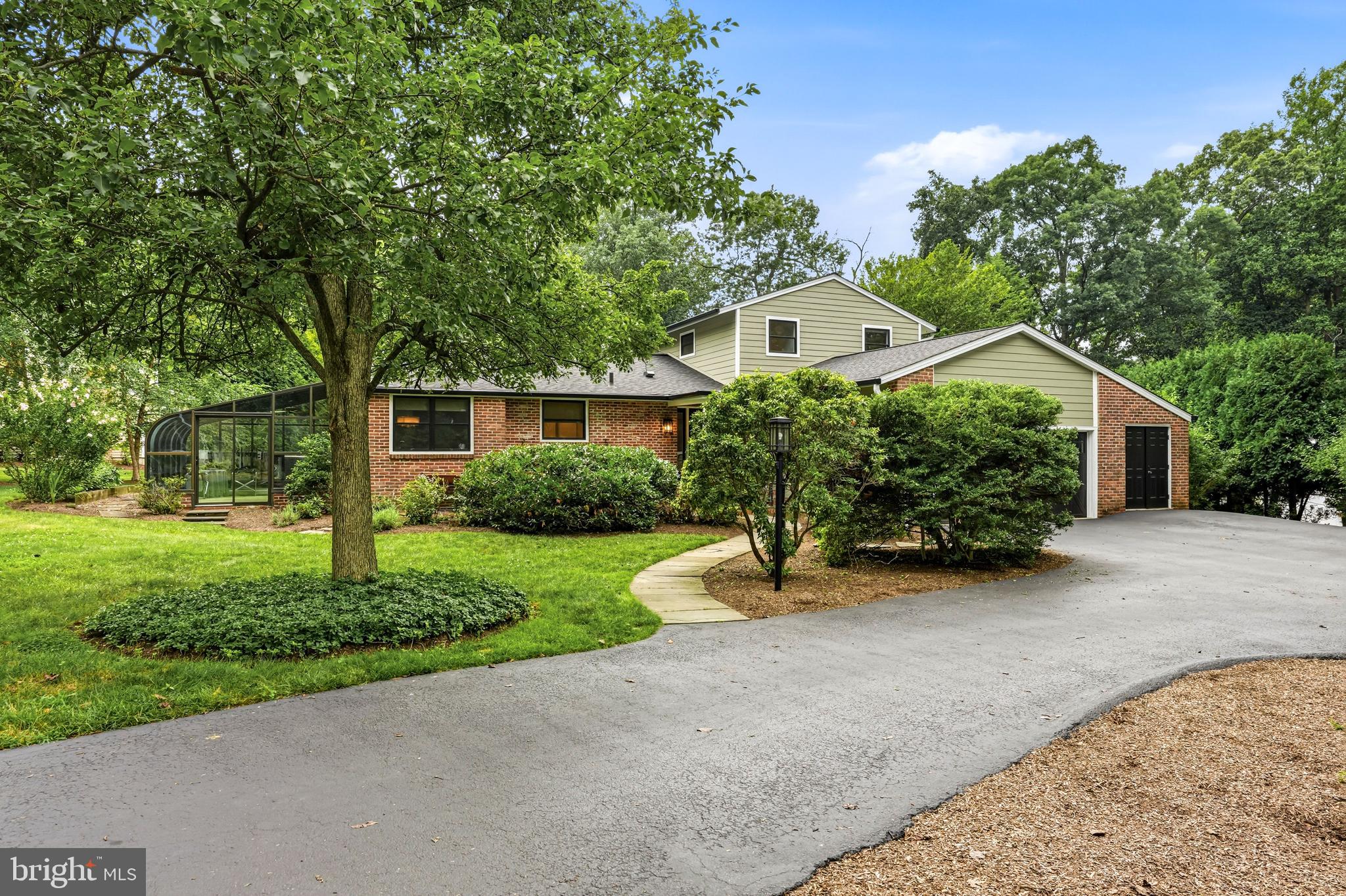 Christmas in July has arrived—and the gift everyone will be talking about is 749 Bair Road. Nestled in Berwyn's coveted Woodlea neighborhood, this exceptional home sits on a perfectly level .76-acre lot, offering the rare combination of timeless Main Line charm, generous living spaces, and an unbeatable walkable lifestyle. Stroll to top-rated schools, the train, restaurants, and neighborhood favorites—all while enjoying the peaceful setting of one of Berwyn's most beloved streets.  A spacious horseshoe driveway and flagstone walkway welcome you to the stately front entrance, where a grand foyer and sweeping staircase set the tone for what lies beyond. Rich hardwood floors lead you into an expansive great room, where built-in bookshelves, a classic brick fireplace, recessed lighting, and panoramic views of the lush backyard create an inviting space for everyday living and memorable gatherings.  The well-appointed kitchen is designed for both function and entertaining, featuring beautiful wood cabinetry, Corian countertops, a gas cooktop, Sub-Zero refrigerator, center island, pantry, and abundant workspace. Just beyond, the dining room showcases authentic Main Line character with exposed wood beams, custom built-ins, a bar area, and rich wood-paneled walls that make every dinner feel like a special occasion. The adjoining sunroom, with its warm terra-cotta tile floors and walls of windows, offers the perfect place to enjoy your morning coffee or unwind at the end of the day, no matter the season.
Convenience meets comfort with a desirable first-floor primary suite, complete with direct access to the flagstone patio, a spacious walk-in closet, and a luxurious bath featuring a soaking tub, separate shower, double vanity, and private water closet.  A second bedroom with its own full bath and a powder room complete the main level.  Upstairs, two generously sized bedrooms are connected by a thoughtfully designed Jack-and-Jill bathroom with a double vanity and ample linen storage, providing comfortable accommodations for family and guests alike.  The finished lower level expands the home's versatility with a spacious family room featuring French doors to the side yard, a wet bar for effortless entertaining, a full bath, laundry room, and abundant storage and workshop space.  Additional highlights include efficient gas hot water heat, central air conditioning, a whole-house backup generator, an attached two-car garage, and additional storage.  And then there's Woodlea—where neighbors become lifelong friends. Annual luminary nights, neighborhood cocktail parties, the familiar sound of the ice cream truck, and abundant wildlife create the kind of community people hope to find but rarely do.   749 Bair Road isn't simply a beautiful home—it's an invitation to experience the Main Line lifestyle so many dream about. Come see why this is the one you've been waiting for.